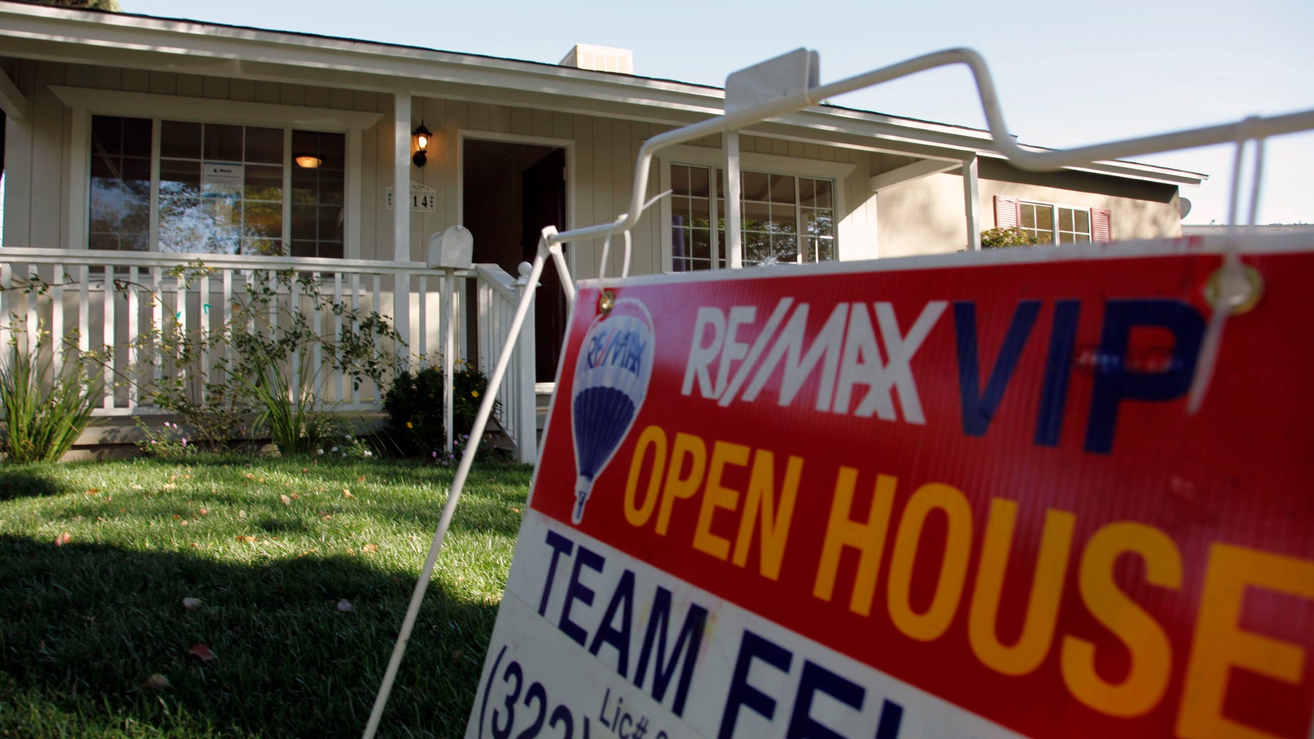 In this Nov. 4, photo, an open house sign is seen on the front lawn of a home for sale in Los Angeles. Home prices are dropping in the nation's largest cities and are expected to fall through next year, with the worst declines coming in areas with high numbers of foreclosures.