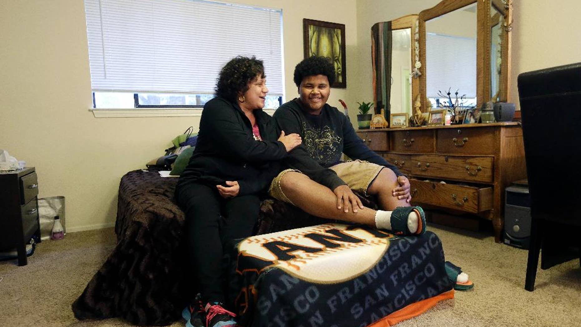 Nov. 13, 2014: In this photo, Gina Cooper, left, and her son Dante Walton, 14, pose for photos at their home in San Carlos, Calif. After a few months as nomads in 2012 when Cooper and Walton, then 12, had to vacate their home when her salary became insufficient to pay the rent, they found shelter and support with an interfaith program and stayed there five months before Cooper saved enough to be able to afford housing on her own.