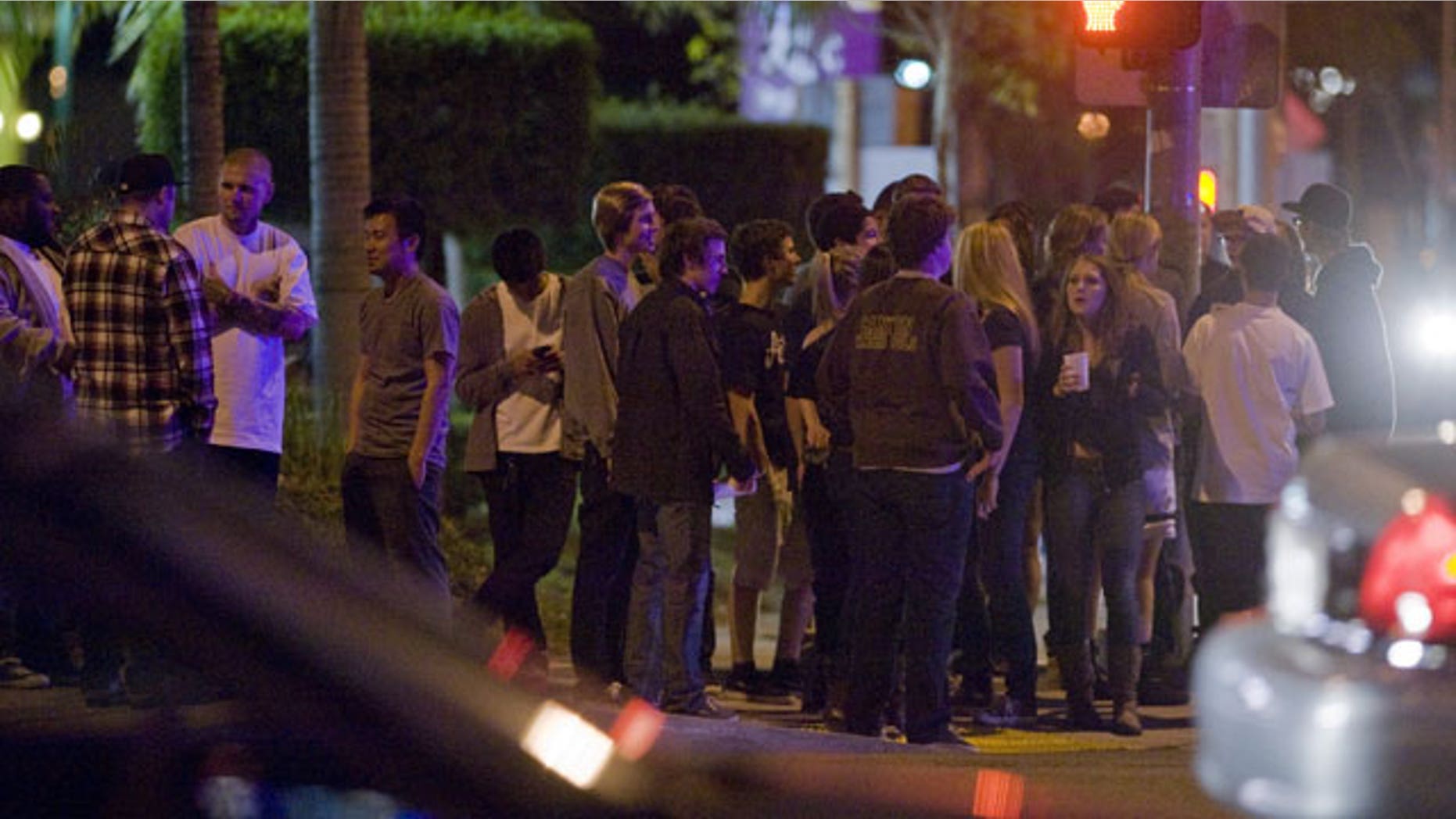 January 13, 2012: A crowd gathers at the intersection of Imperial Highway and La Palma in Anaheim, Calif. Friday night following the discovery of a dead man behind a Carl's Jr.