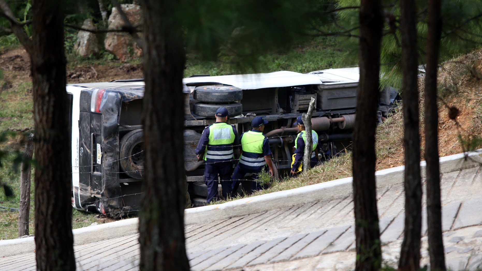 This photo courtesy of El Heraldo de Honduras newspaper shows a bus on its side along the highway between the town of San Juancito and the capital city of Tegucigalpa, Honduras, Wednesday, Jan. 13, 2016. Two New York college students and a U.S. health-care worker died Wednesday in this Central American nation when their bus crashed while taking them to the airport to fly home after a volunteer mission helping poor Hondurans. (El Heraldo de Honduras via AP)