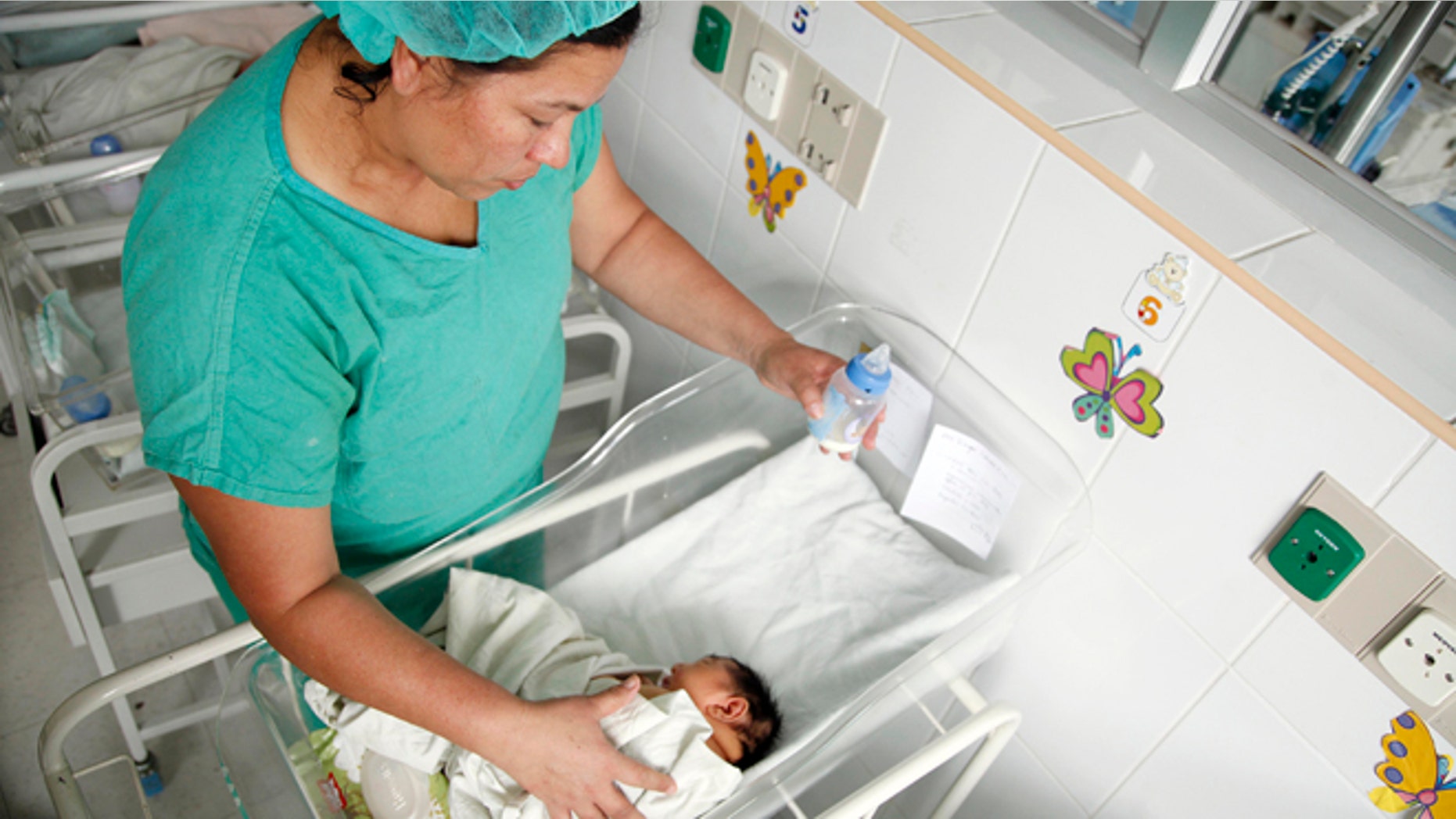 A nurse bottle feeds a newborn baby aflicted with microcephaly at a maternity ward of the University Hospital in Tegucigalpa, Honduras, Tuesday, July 26, 2016. Honduras' health minister, Dr. Yolani Batres, says eight babies with severe birth defects linked to the Zika virus have been born in the Central American country. Some women who contract Zika during their pregnancies have given birth to babies with microcephaly, which leads to babies with abnormally small heads and improperly developed brains. (AP Photo/Fernando Antonio)