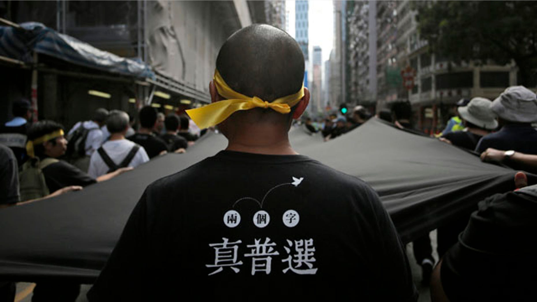 September 14, 2014: A protester stretches out a 500 meter long black cloth during a rally in a downtown street in Hong Kong. The Chinese words on the T-shirt read 'Real Universal Suffrage'. (AP Photo/Vincent Yu)