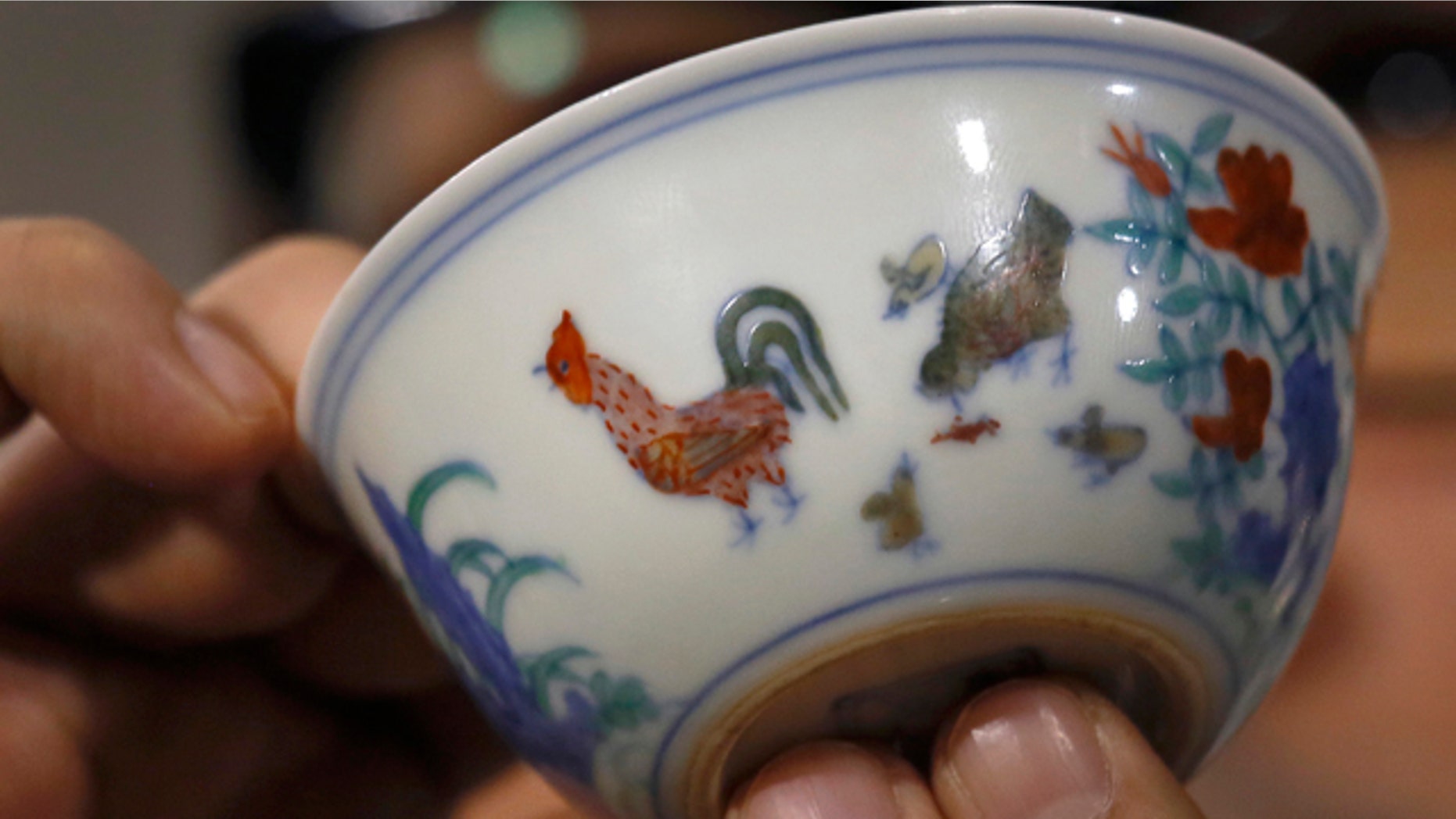 April 8, 2014: The Meiyintang Chicken Cup from the Chinese Ming Dynasty (1368-1644) is displayed during a press conference in Hong Kong. Sothebys said Shanghai collector Liu Yiqian won the bidding for the Chicken Cup, which is decorated with a rooster, hen and their chicks. Including the auction house's commission, the price for the small cup comes to $36.1 million, which Sothebys said is a world record price for Chinese porcelain. (AP Photo/Vincent Yu)