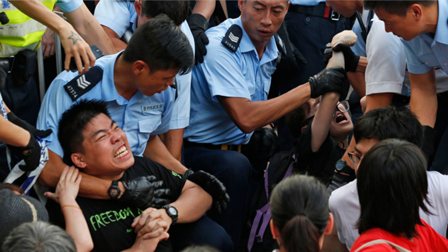 July 2, 2014: Protesters are taken away by police officers after staging a peaceful sit-in overnight on a street in the financial district in Hong Kong. (AP Photo/Kin Cheung)