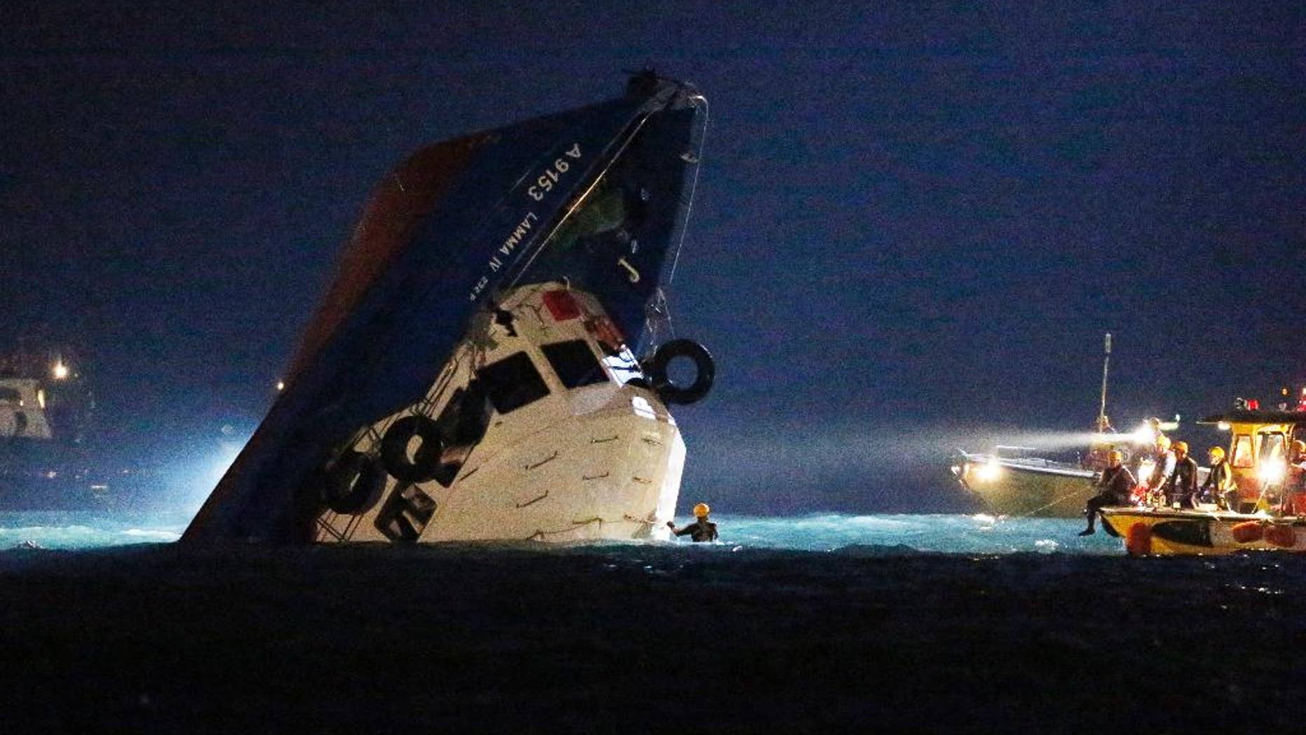 FILE - In this Oct. 2, 2012 file photo, rescuers check on a half submerged boat after it collided near Lamma Island, off the southwestern coast of Hong Kong. The captain of the Hong Kong commuter ferry that collided with another boat, killing 39 people, was found guilty of manslaughter on Saturday, Feb. 14, 2015 local media reported. A nine-member jury also found Lai Sai-ming guilty of endangering the safety of others at sea, in what was Hong Kong's biggest maritime tragedy in decades, the South China Morning Post newspaper and Radio Television Hong Kong said. (AP Photo/Kin Cheung, File)