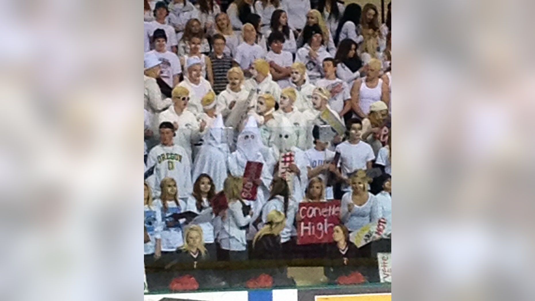 Feb. 22, 2013: In this photo provided by Shane Schuster, three people in the Red River High School student section wear Ku Klux Klan-style white robes and hoods during a semifinal game in the North Dakota Boys Hockey Tournament at Ralph Engelstad Arena in Grand Forks, N.D.