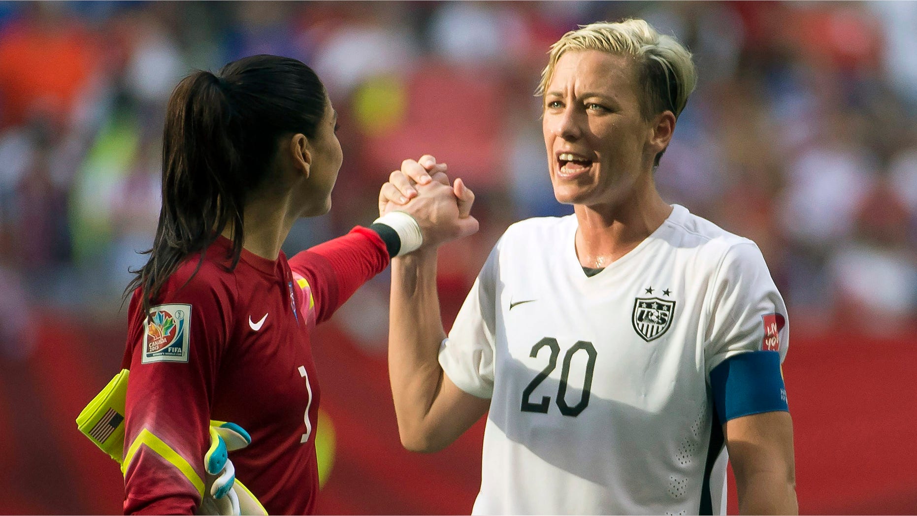 United States' Abby Wambach (20) celebrates her team's win with goal keeper Hope Solo following the second half of a FIFA Women's World Cup soccer match, Tuesday, June 16, 2015 in Vancouver, New Brunswick, Canada (Jonathan Hayward/The Canadian Press via AP) MANDATORY CREDIT