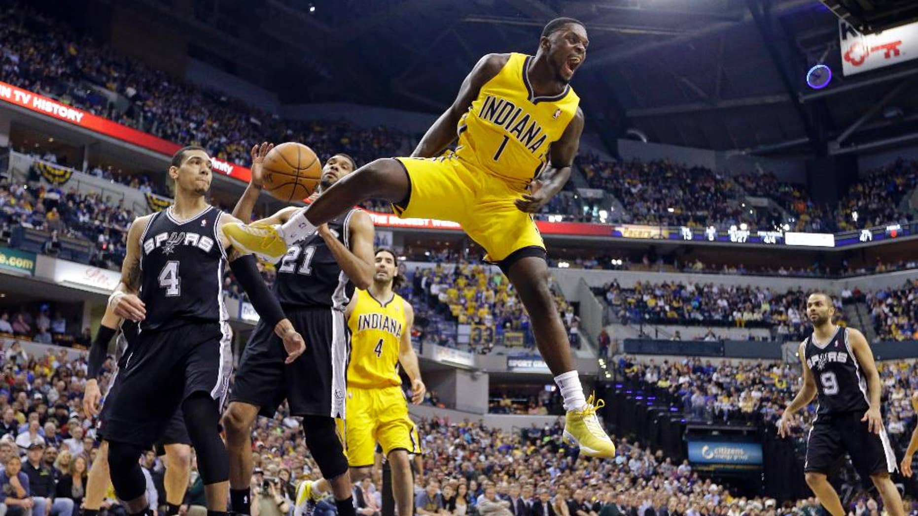 FILE - In this March 31, 2014, file photo, Indiana Pacers guard Lance Stephenson (1) reacts after a slam dunk over San Antonio Spurs guard Danny Green (4) and forward Tim Duncan (21) during the first half of an NBA basketball game in Indianapolis. A person familiar with the contract says free-agent shooting guard Lance Stephenson has agreed to a $27 million, three-year deal with the Charlotte Hornets. The deal includes a team option for the third season. (AP Photo/Michael Conroy, File)