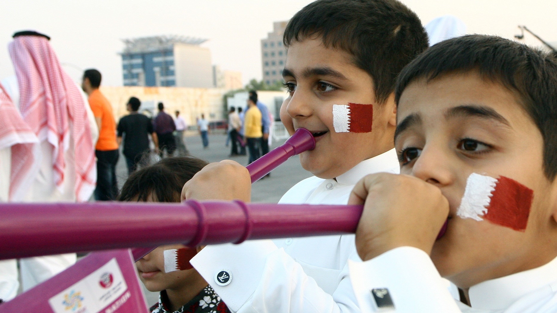 Thursday: Qatari boys with their faces painted in the colors of their national flag, blow vuvuzelas, at the capital Doha's traditional souk, where people gathered to follow FIFA's selection of Russia and Qatar to host the World Cups in 2018 and 2022, respectively.