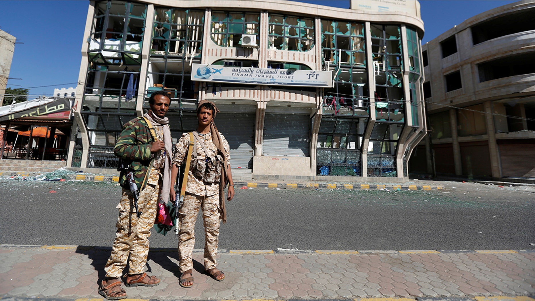 Houthi fighters pose for a photo in front of a damaged building on a street where Houthis have recently clashed with forces loyal to slain Yemeni former president Ali Abdullah Saleh in Sanaa, Yemen December 6, 2017. REUTERS/Khaled Abdullah - RC1A7A92EC80