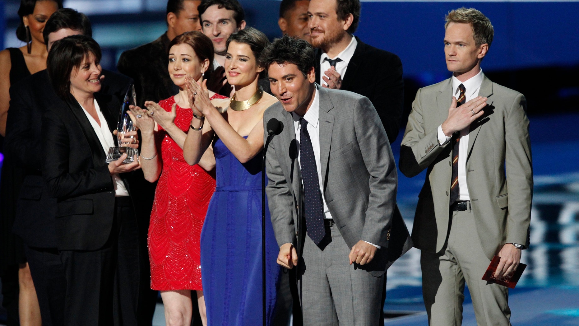 Actor Josh Radnor, center, accepts the Favorite Network TV Comedy award for TV series "How I Met Your Mother" at the 2012 People's Choice Awards in Los Angeles January 11, 2012.