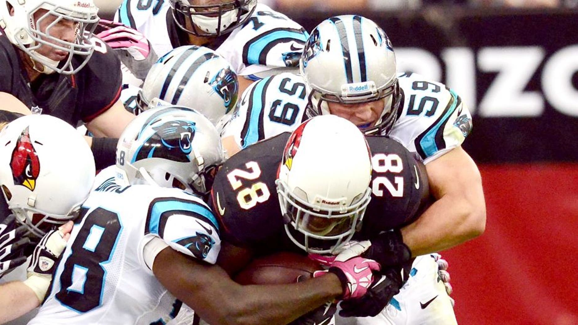 GLENDALE, AZ - OCTOBER 06: Rashard Mendenhall #28 of the Arizona Cardinals runs with the ball while dragging Thomas Davis #58 and Luke Kuechly #59 of the Carolina Panthers down the field at University of Phoenix Stadium on October 6, 2013 in Glendale, Arizona. Arizona won 22-6. (Photo by Norm Hall/Getty Images)