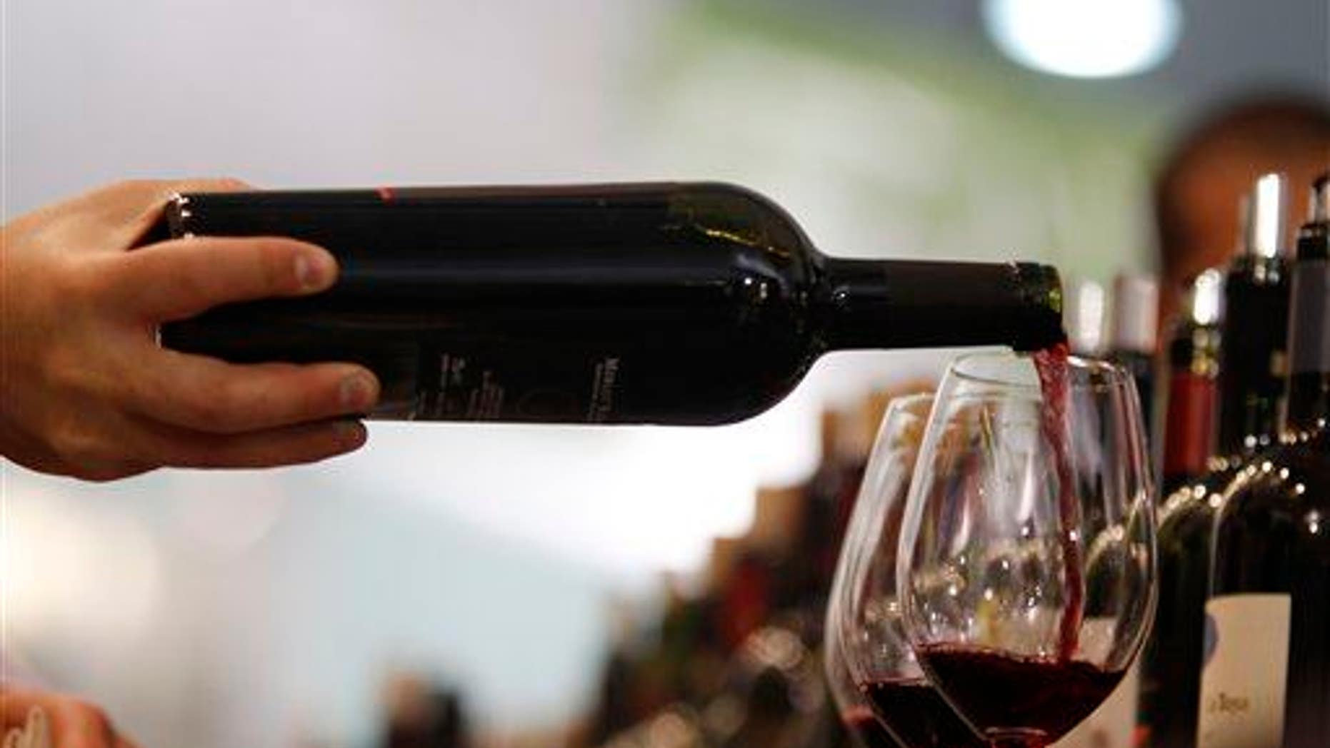 A glass of red wine is poured.