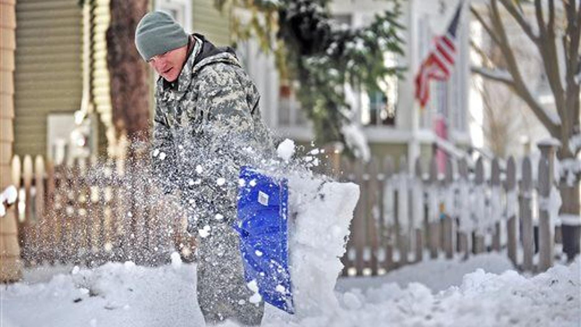 Spc. Cory Amato, from Fort Drumm, shovels snow from the sidewalk outside his house on Franklin Street Wednesday, Nov. 19, 2014, in Watertown, N.Y.