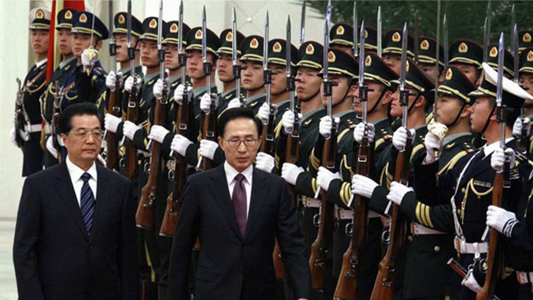 January 9, 2012: South Korean President Lee Myung-bak (2nd L) walks with Chinese President Hu Jintao (L) as they inspect a guard of honor during an official welcoming ceremony in the Great Hall of the People in Beijing.