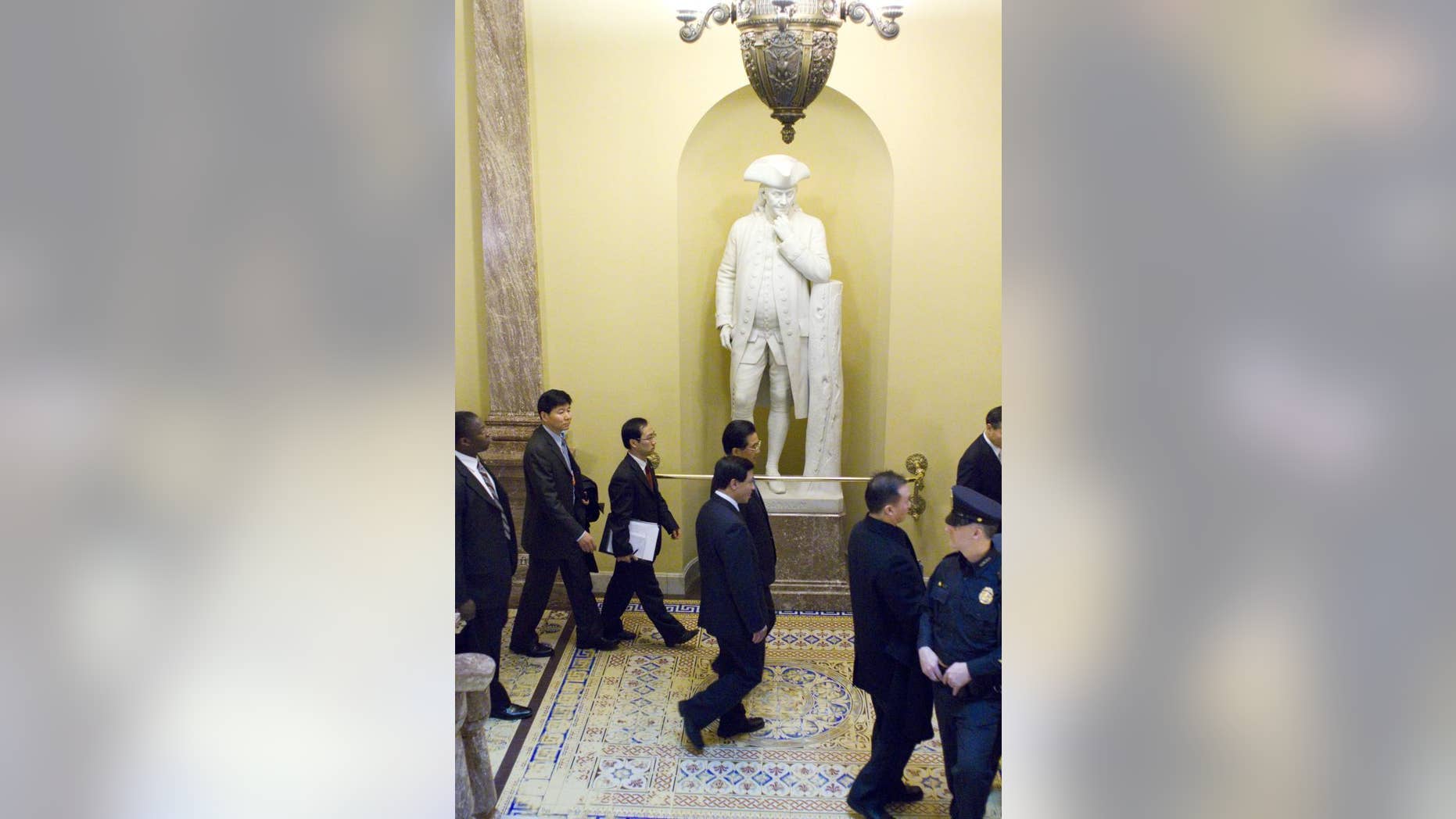 China's President Hu Jintao walks by a statue of Ben Franklin, Thursday, Jan. 20, 2011, on Capitol Hill in Washington. (AP Photo/Harry Hamburg)