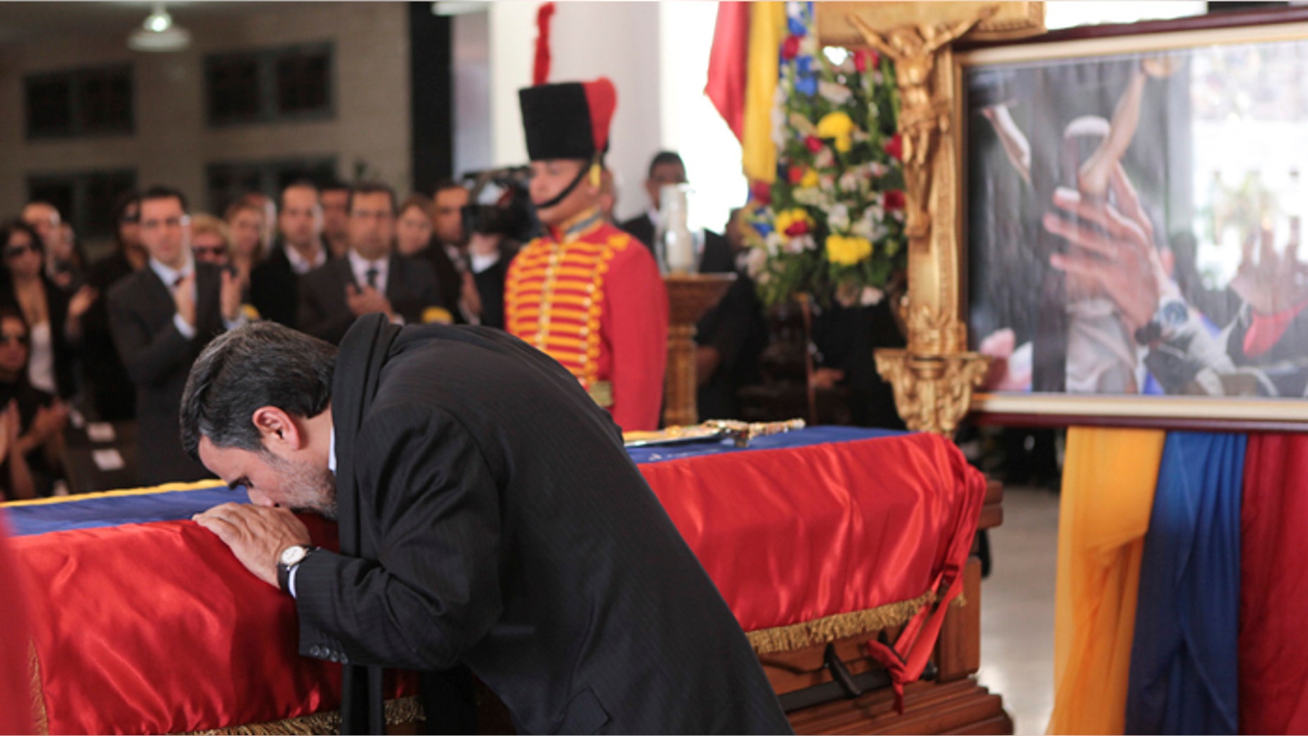 Iran's President Mahmoud Ahmadinejad pays tribute to late Venezuelan President Hugo Chavez, during the funeral service at the Military Academy in Caracas March 8, 2013.