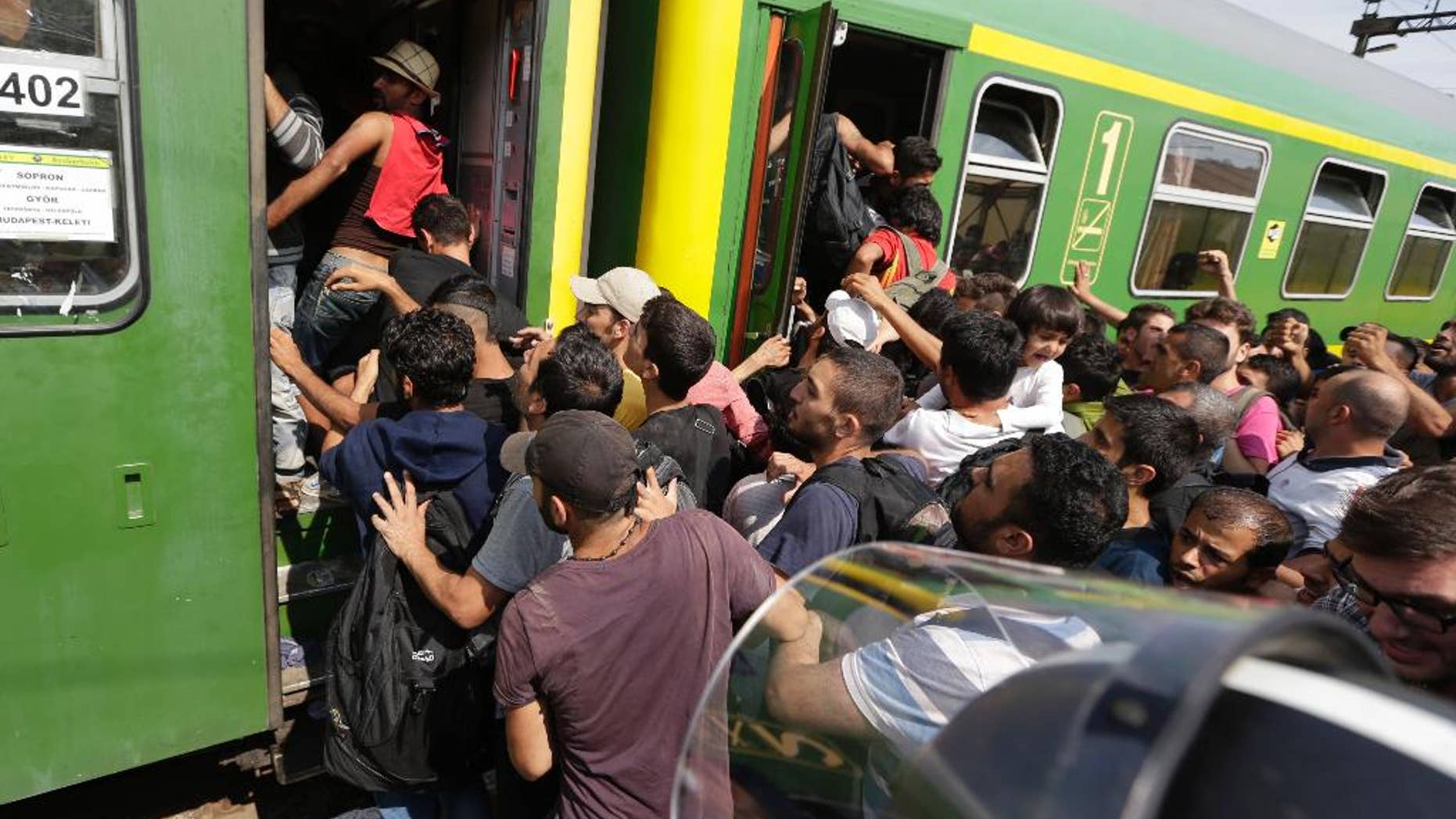 Migrants get back on a train in Bicske, Hungary, Thursday, Sept. 3, 2015. Over 150,000 migrants have reached Hungary this year, most coming through the southern border with Serbia. Many apply for asylum but quickly try to leave for richer EU countries. (AP Photo/Petr David Josek)