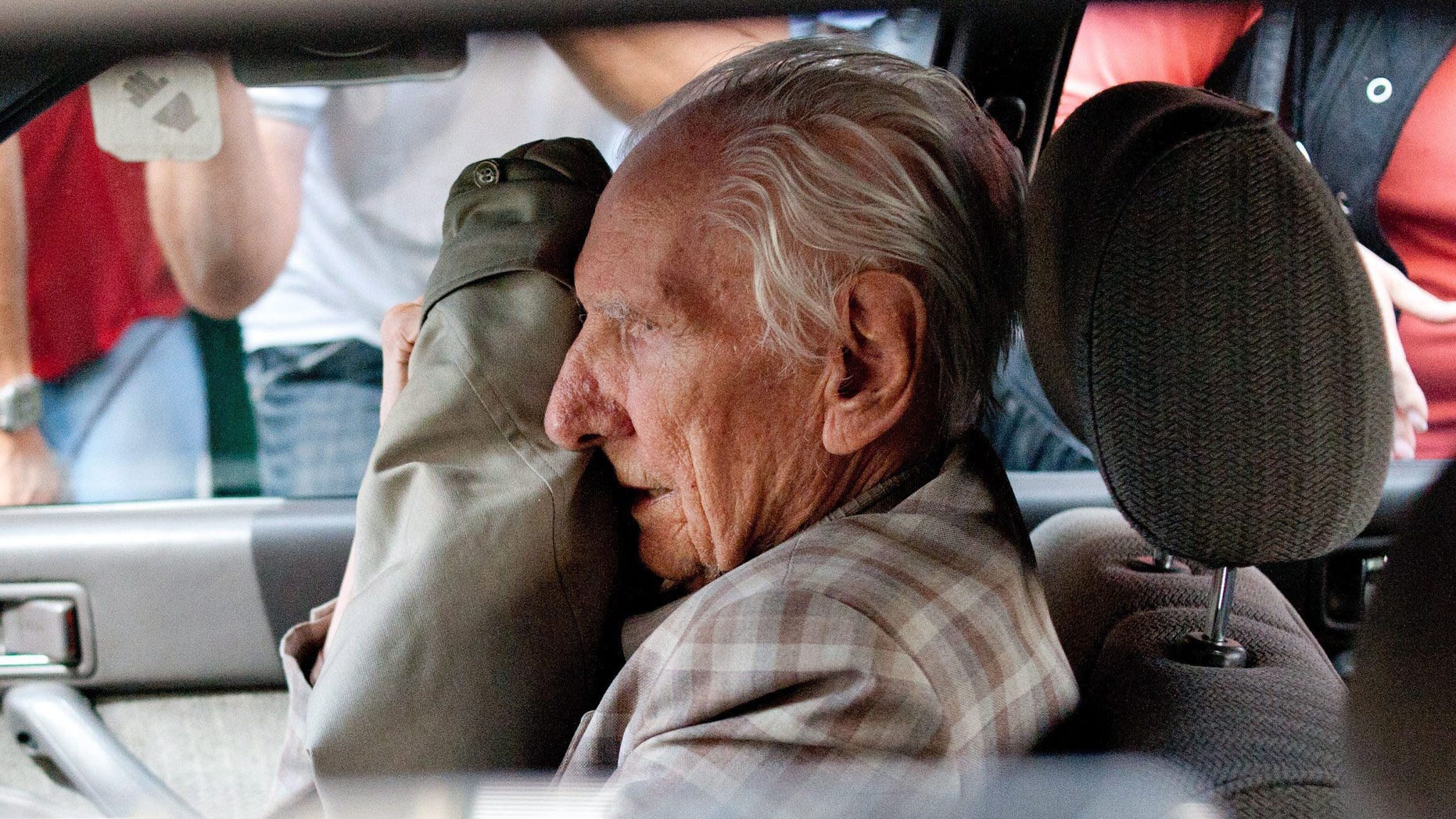 July 18, 2012 - FILE photo shows alleged Hungarian war criminal Laszlo Csatary covering his face in a car as he leaves the Budapest Prosecutor's Office after he was questioned by detectives on charges of war crimes during WWII and prosecutors ordered his house arrest in Budapest, Hungary. Csatary, a former police officer indicted in June 2013 by Hungarian authorities for abusing Jews and contributing to their deportation to Nazi death camps during World War II, has died.