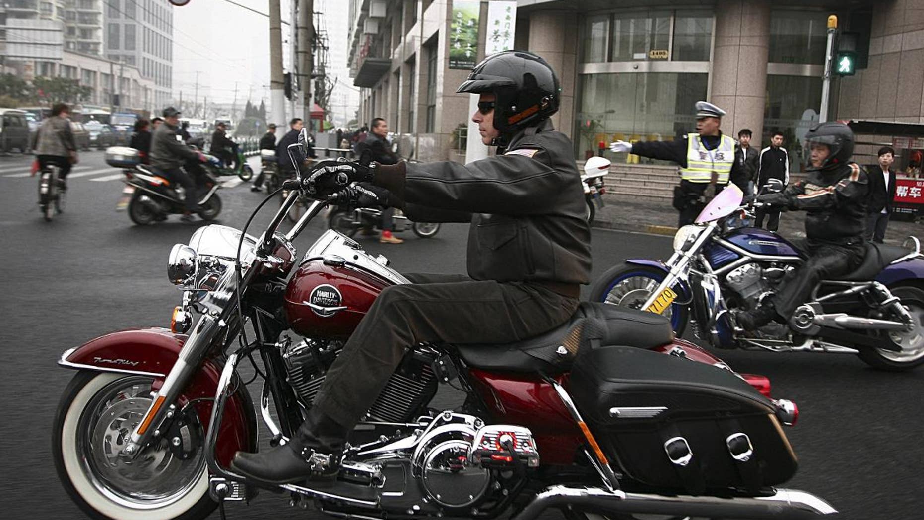 U.S. Ambassador to China Jon Huntsman rides a Harley-Davidson motorbike cruise around town in Shanghai, China Thursday April 7, 2011. Huntsman is in Shanghai to deliver a farewell speech at the Barnett-Oksenberg Lecture before heading back to U.S. later this month. (AP Photo)