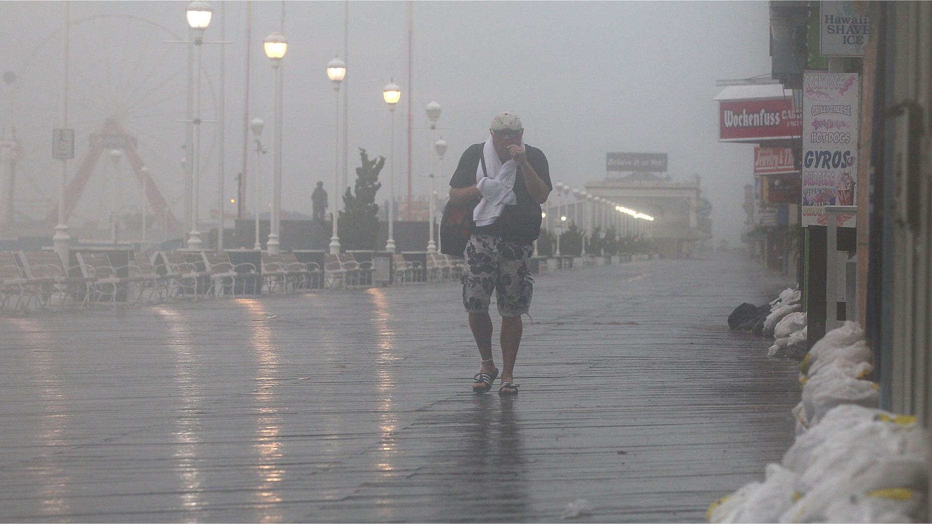 OCEAN CITY, MD - AUGUST 27: A man walks down the board walk as winds from approaching Hurricane Irene start hit the area on August 27, 2011 in Ocean City, Maryland. The state of Maryland has declared a state of emergency as heavy winds and surf from Hurricane Irene approaches the coast. (Photo by Mark Wilson/Getty Images)