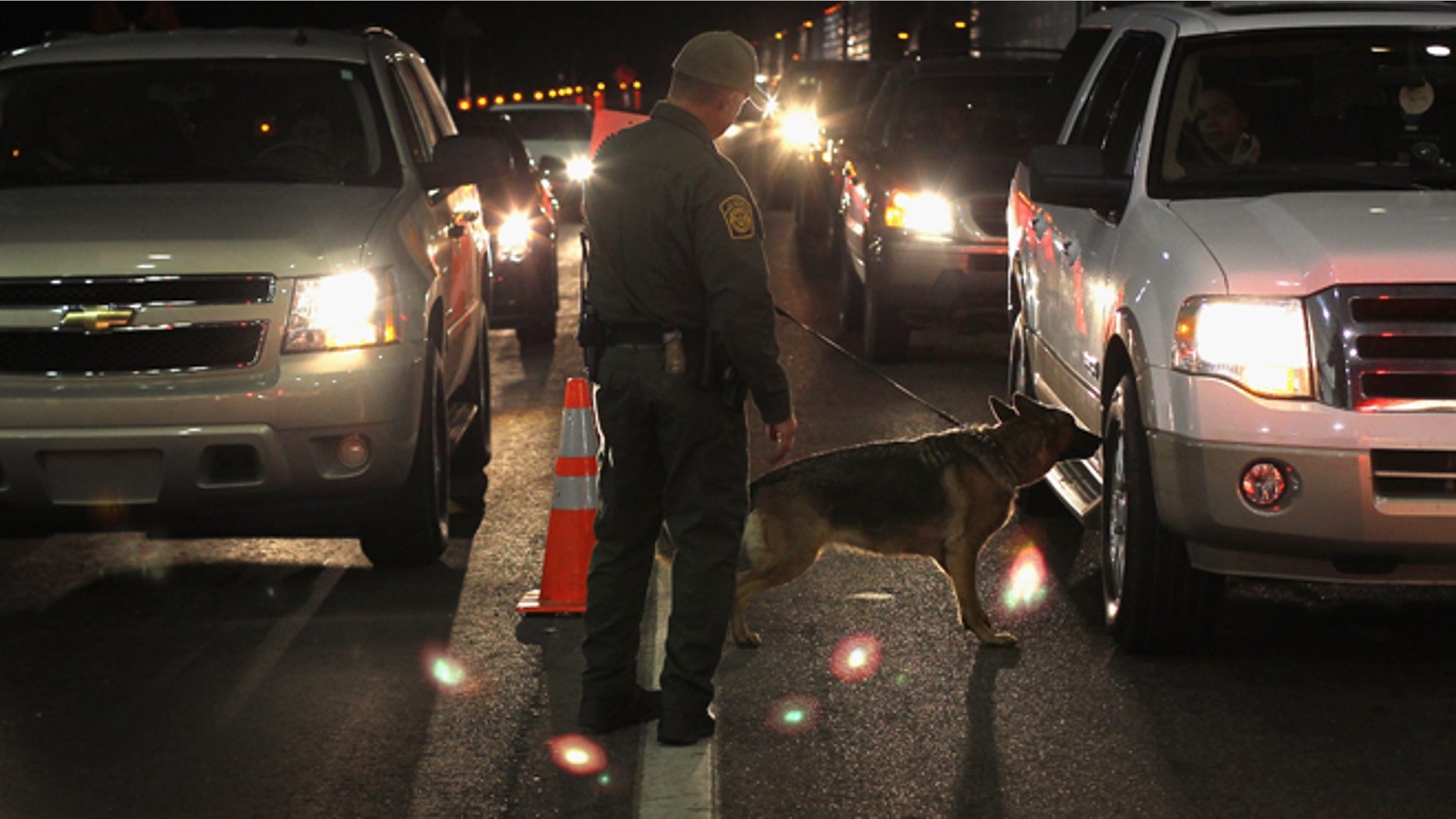 NOGALES, AZ - DECEMBER 07: A border patrol agent and Gitta, a drug-sniffing German shepherd, work a checkpoint on December 7, 2010 north of Nogales, Arizona. The checkpoint falls in the Tucson sector of the U.S.- Mexico border and is considered the most heavily trafficked by illegal immigrants and drug smugglers in the United States. (Photo by John Moore/Getty Images)