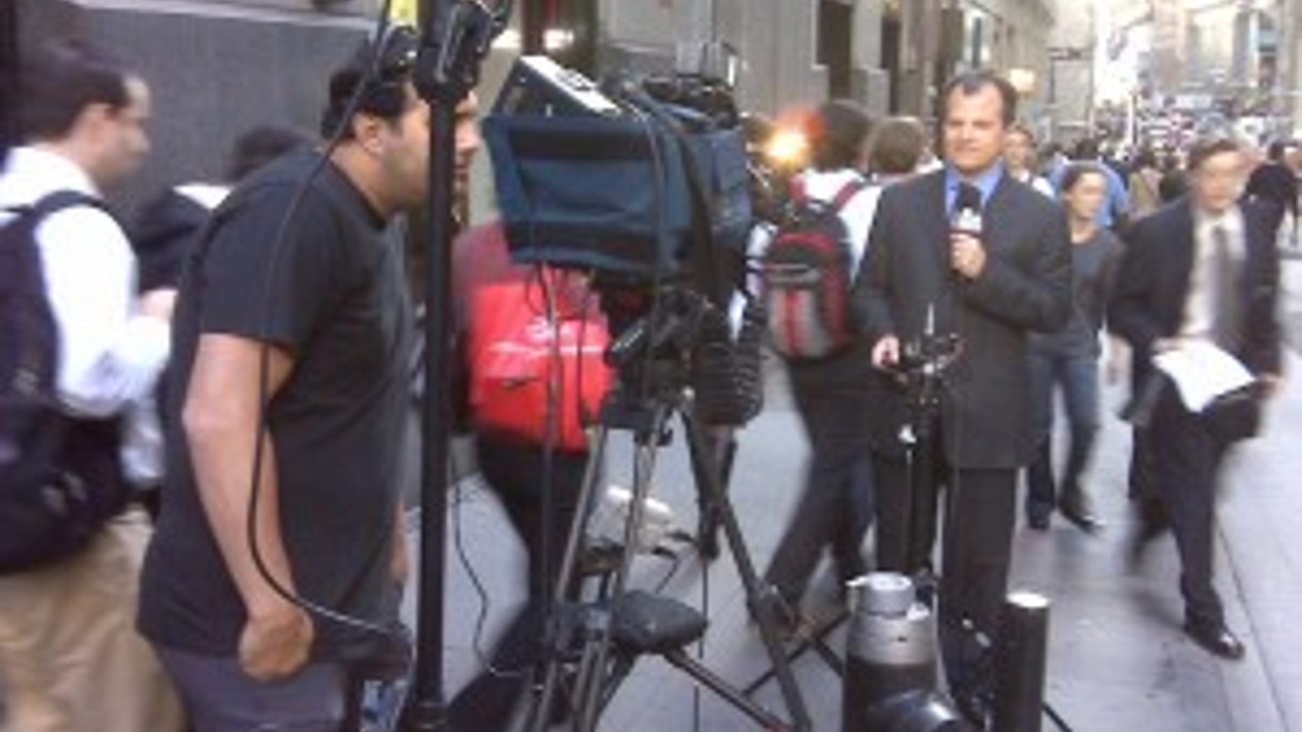 Mike Emanuel reports from Wall Street. Photographer John Kisala makes sure the shot is lined up.