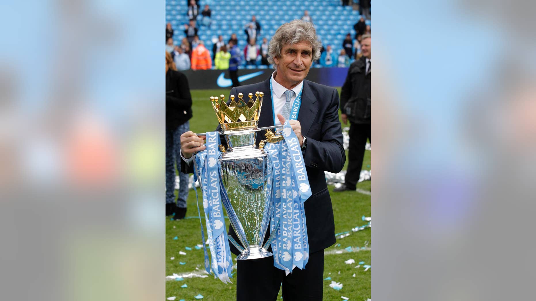 El chileno Manuel Pellegrini, técnico del Manchester City, posa para los fotógrafos con el trofeo de la liga Premier inglesa tras el último partido de la temporada contra el West Ham en el estadio Etihad, en Manchester, Inglaterra, el domingo 11 de mayo de 2014. El City se coronó el domingo campeón con una cómoda victoria 2-0 sobre el West Ham. (AP Foto/Jon Super)