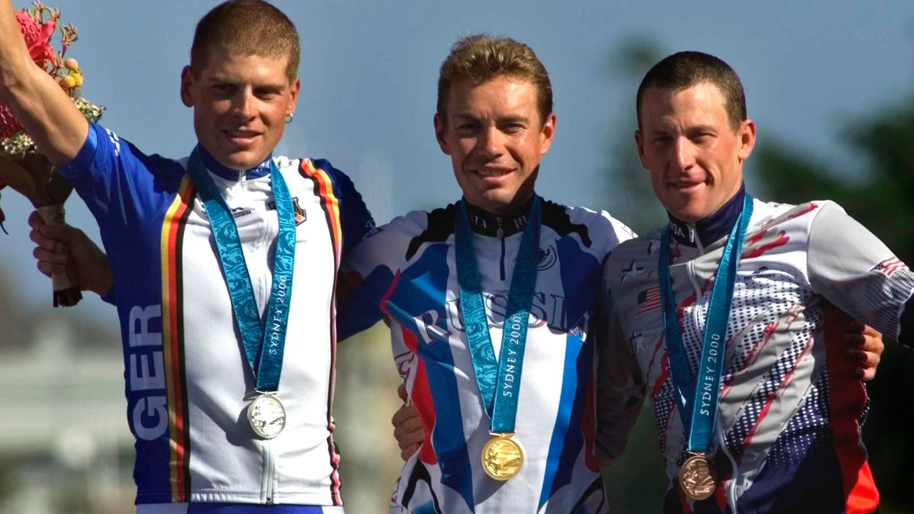 Sept. 30, 2000: In this file photo Russia's Viacheslav Ekimov, center, winner of the gold medal in the men's individual time trials, celebrates with Germany's silver medal winner Jan Ullrich, left, and U.S bronze medal winner Lance Armstrong at the cycling road course in Sydney, for the Summer Olympic Games.