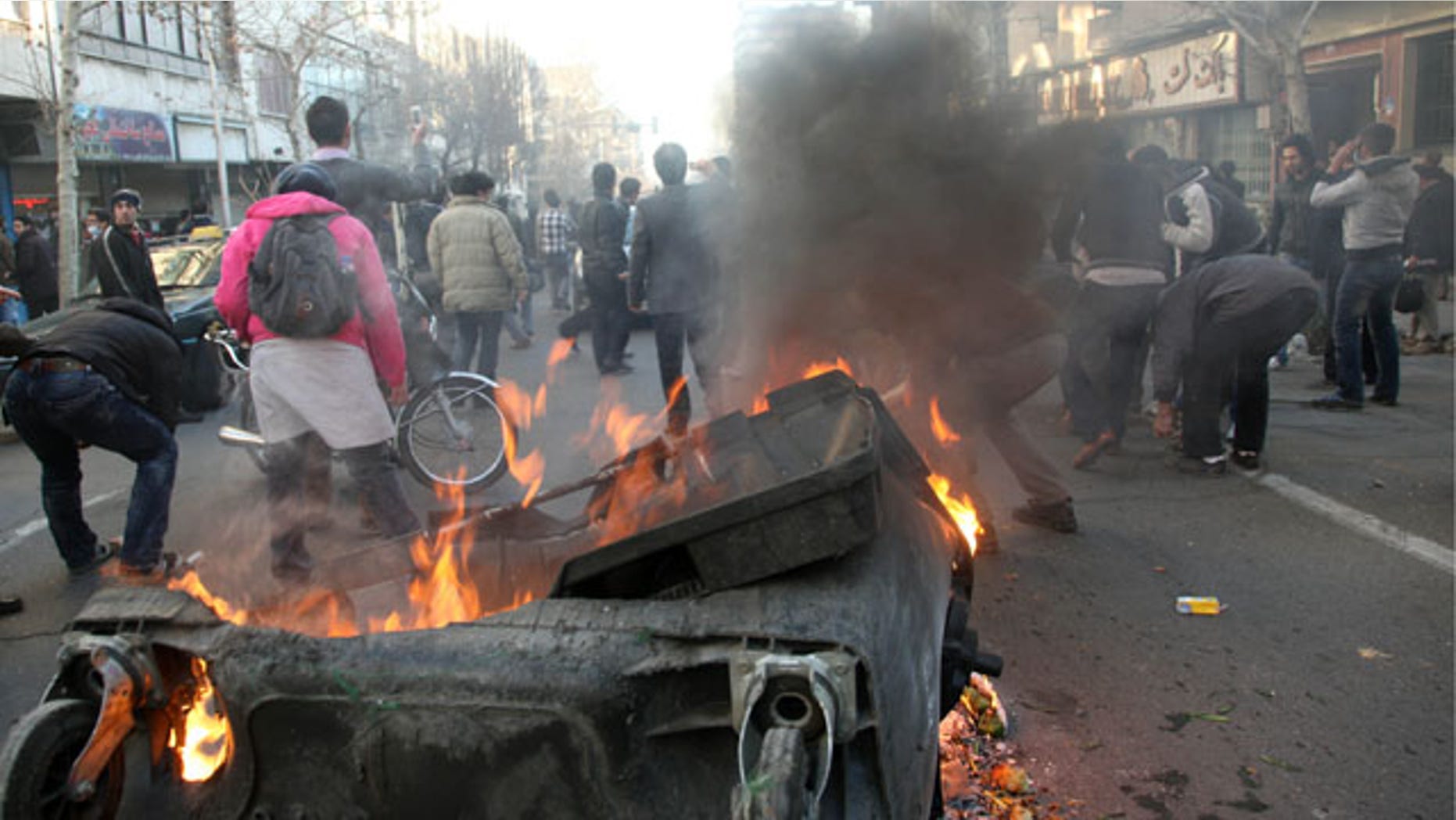 Feb. 14, 2011: This photo shows Iranian protestors attending an anti-government protest as a garbage can is set on fire, in Tehran, Iran.