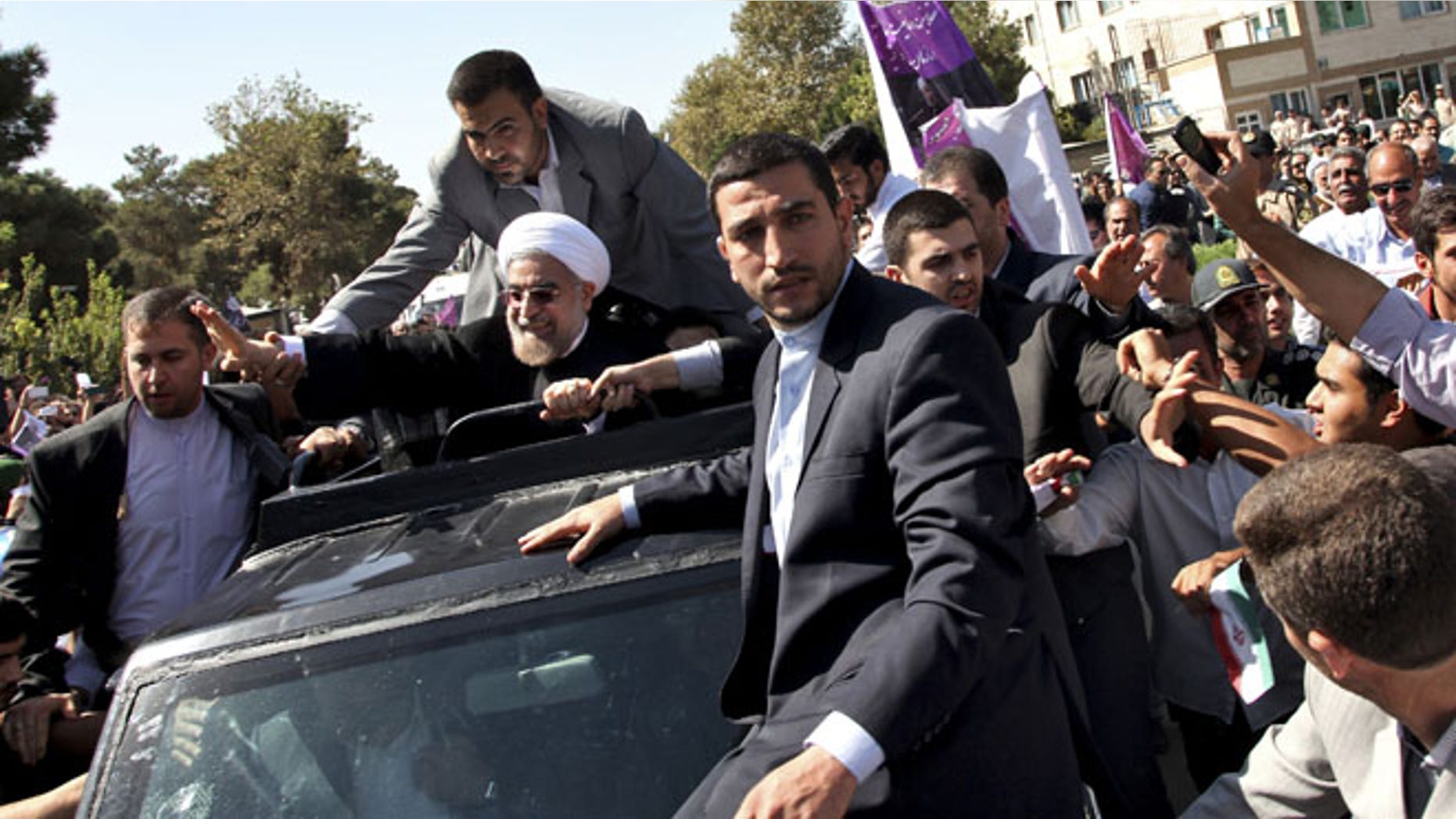 Sept. 28: Iranian President Hassan Rouhani, center, waves to supporters upon his arrival from the US near the Mehrabad airport in Tehran, Iran.