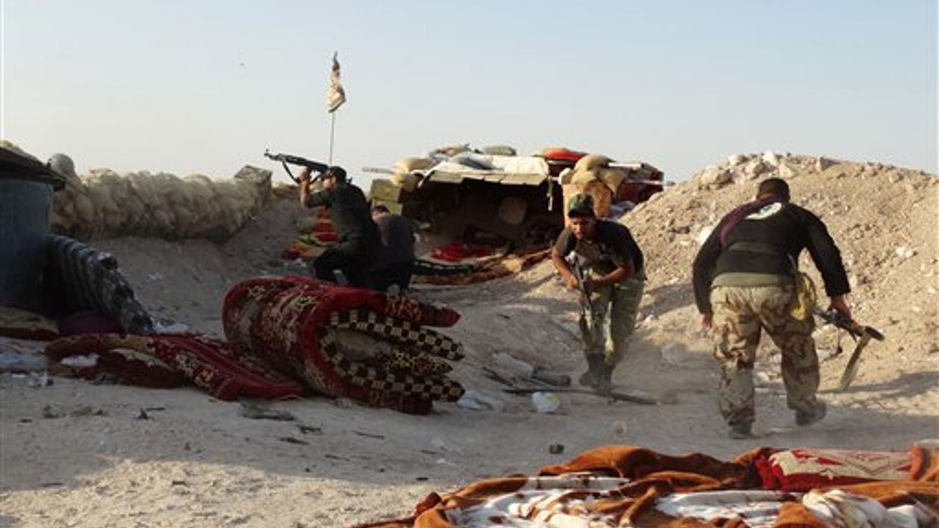 In this photo taken Monday, June 15, 2015, Iraqi security forces defend their positions against an Islamic State attack in Husaybah, 5 miles east of Ramadi, Iraq. (AP Photo)