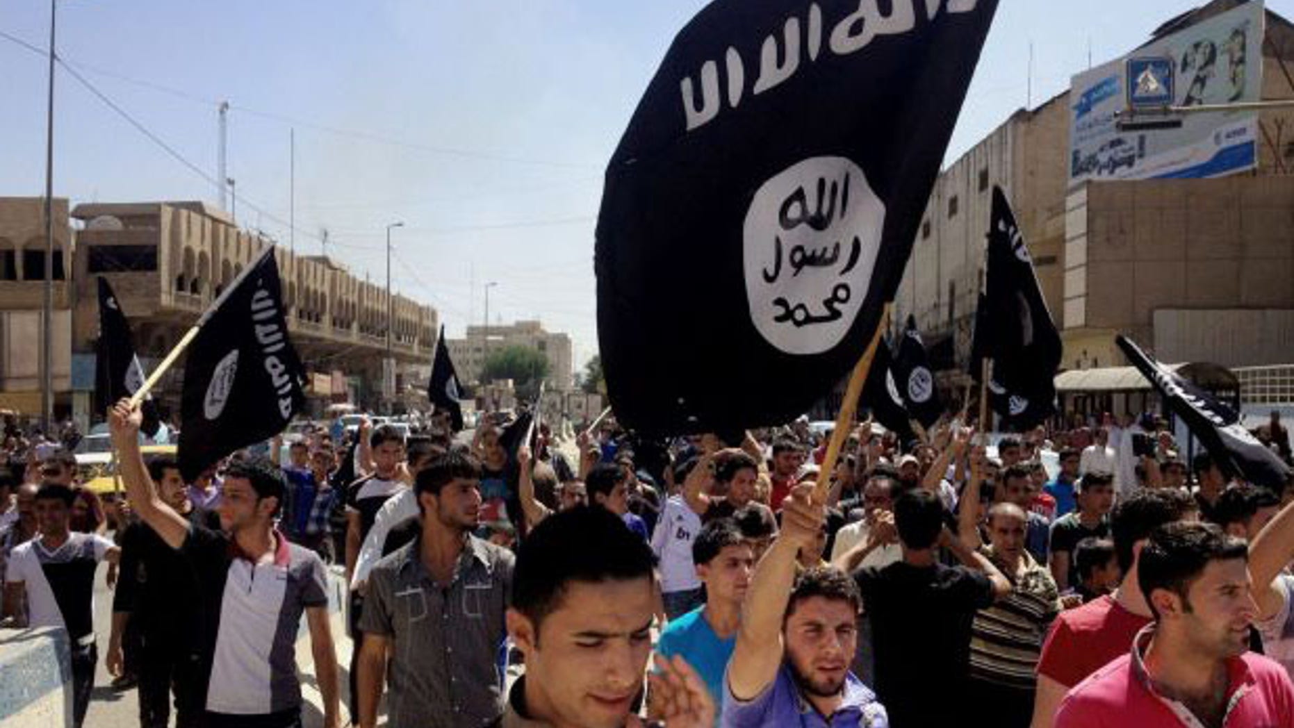 June 16, 2014: Demonstrators chant pro-Islamic State group slogans as they wave the group's flags in front of the provincial government headquarters in Mosul.