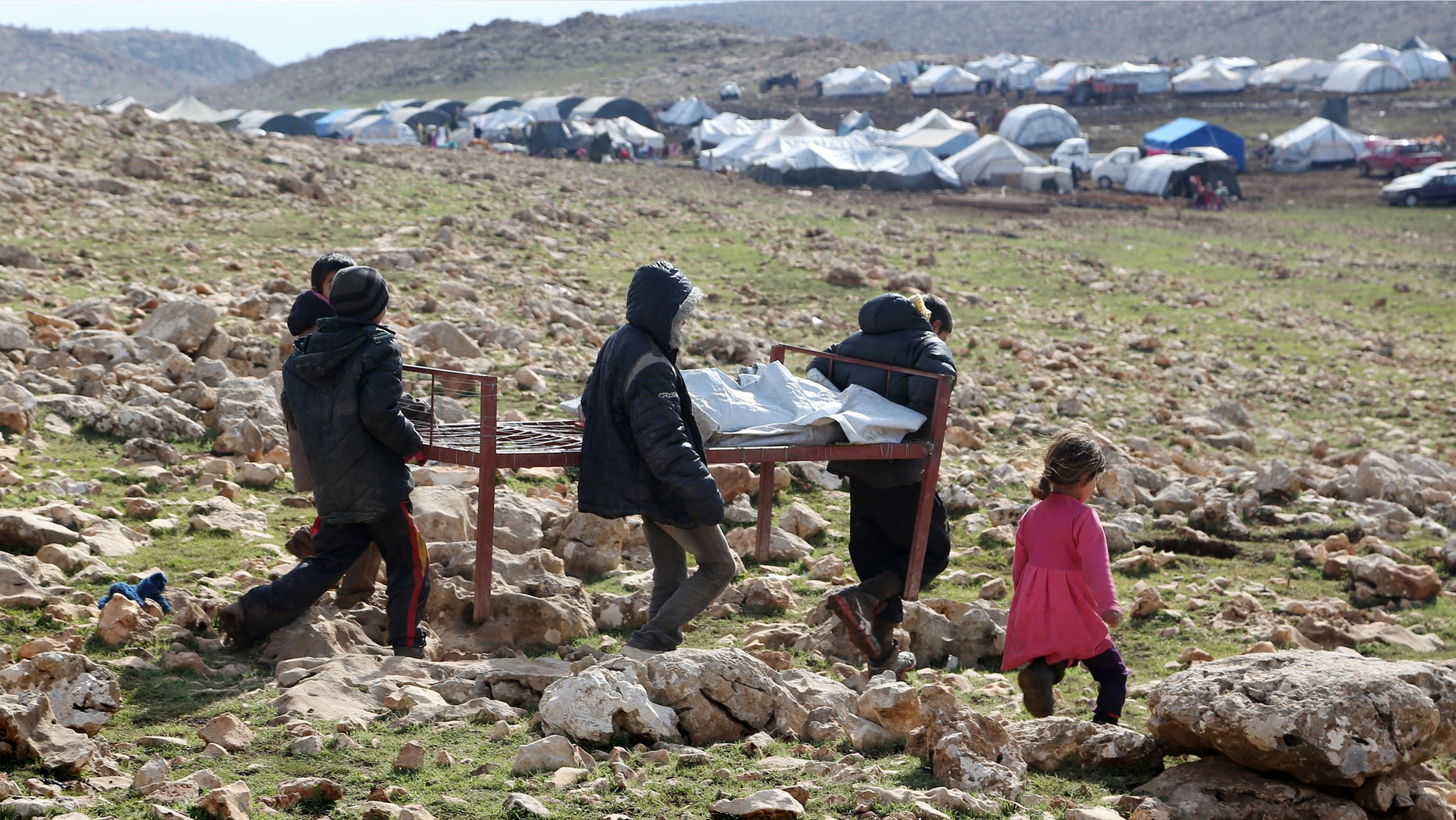 Jan. 12, 2015: Iraqis from the Yazidi minority carry a bed frame on Mount Sinjar in northern Iraq.