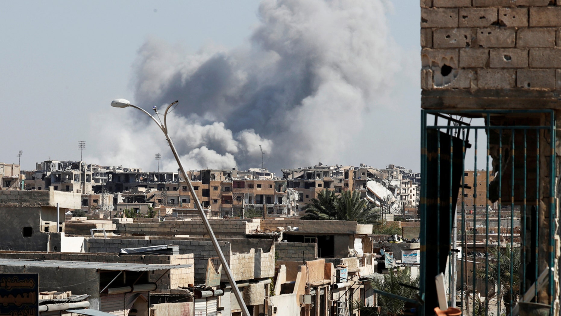Smoke rises near a stadium where some Islamic State militants are holed up after an air strike by coalition forces, in Raqqa, Syria, Oct. 12, 2017.