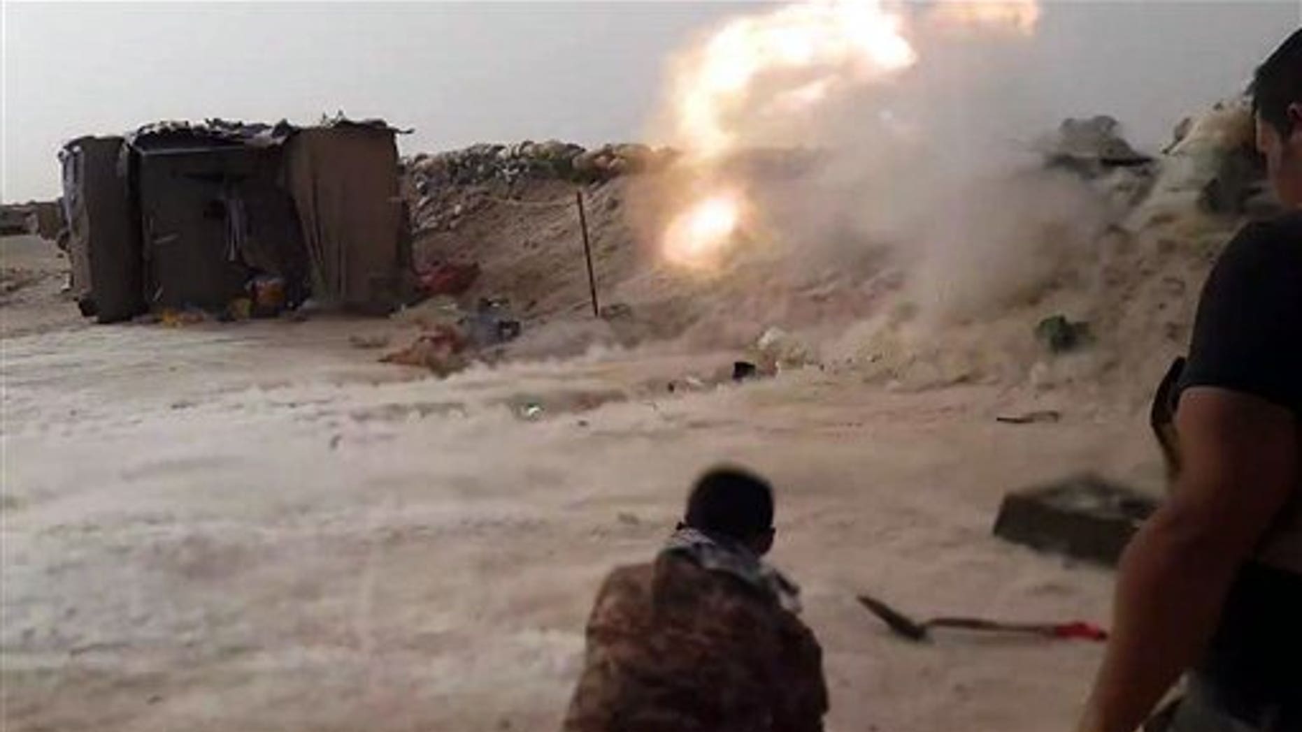 In this image taken Friday, May 29, 2015, Iraqi anti-terrorism forces battle with Islamic State group extremists as they defend their base against attack outside Fallujah, 40 miles (65 kilometers) west of Baghdad, Iraq. (AP Photo)