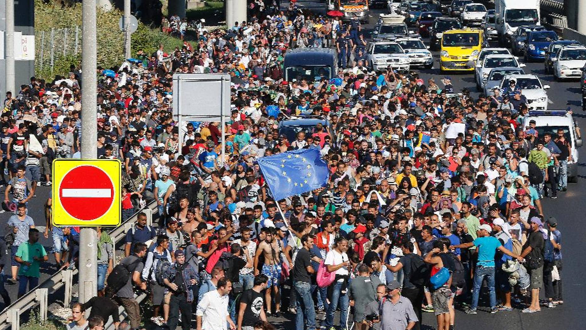 FILE - In this Friday Sept. 4, 2015 file photo, migrants walk out of Budapest, Hungary. As much of Europe hesitates, Iceland, which has just in recent years emerged from the effects of a devastating economic meltdown, seems to be warming to the idea of taking in Syrians fleeing their war-torn homeland. It’s a historic shift for an island that has long been reluctant to take in foreigners. (AP Photo/Frank Augstein, File)