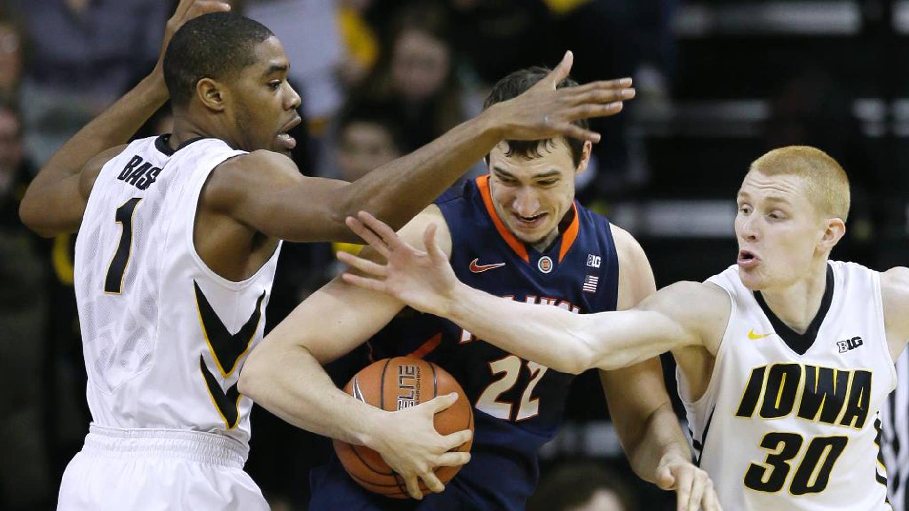 Illinois center Maverick Morgan, center, looks to drive between Iowa's Melsahn Basabe, left, and Aaron White, right, during the first half of an NCAA college basketball game on Saturday, March 8, 2014, in Iowa City, Iowa. (AP Photo/Charlie Neibergall)