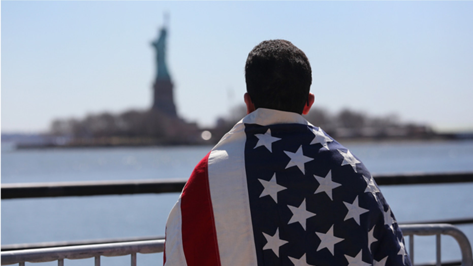 JERSEY CITY, NJ - APRIL 06: Ecuadorian immigrant Diego Cazar, now living in the U.S. for 12 years, looks towards the Statue of Liberty while participating in a "Time is Now" rally for immigration reform on April 6, 2013 in Jersey City, New Jersey. Labor unions and immigration reform advocacy organizations held the event at Liberty State Park to urge Congress to find a path to American citizenship for the estimated 11 million undocumented immigrants living in the United States. (Photo by John Moore/Getty Images)
