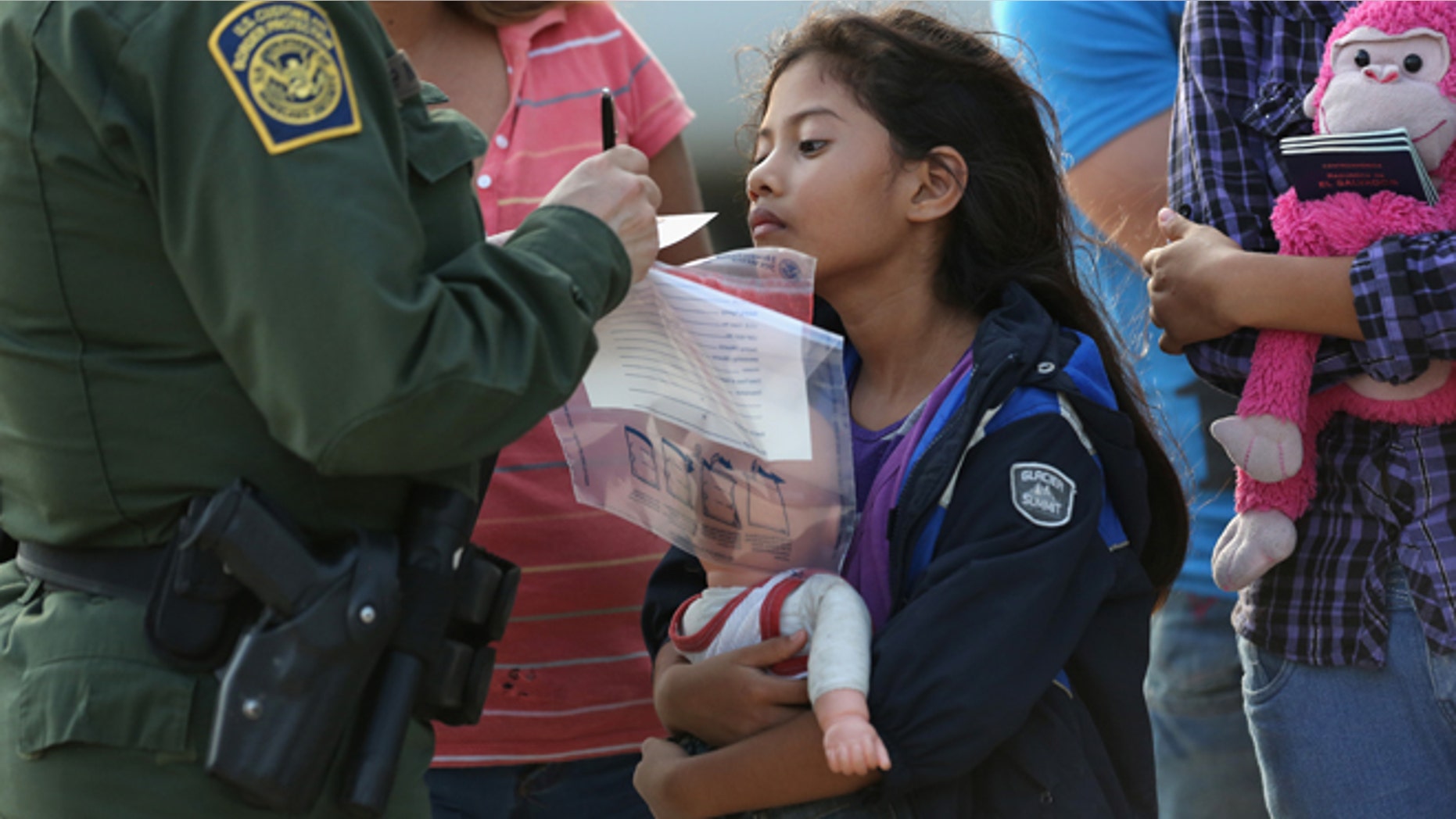 MISSION, TX - JULY 24: Salvadorian immigrant Stefany Marjorie, 8, watches as a U.S. Border Patrol agent records family information on July 24, 2014 in Mission, Texas. Like most of the recent surge of Central American immigrant women and children, her family brought documents, often birth certificates, to prove their nationality to U.S. Border officials. Tens of thousands of immigrant families and unaccompanied minors from Central America have crossed illegally into the United States this year and presented themselves to federal agents, causing a humanitarian crisis on the U.S.-Mexico border. Texas' Rio Grande Valley has become the epicenter of the latest immigrant crisis, as more of them enter illegally from Mexico into that sector than any other stretch of the America's 1,933 mile border with Mexico. (Photo by John Moore/Getty Images)