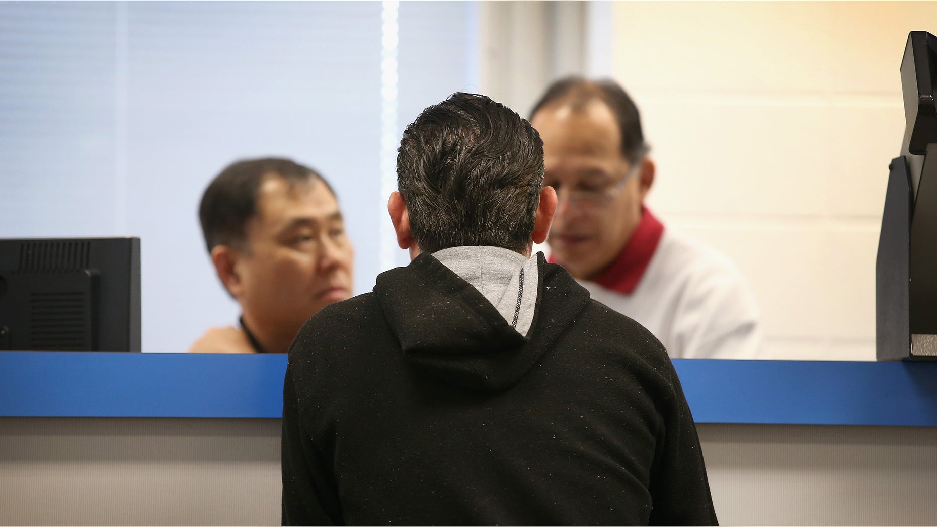 CHICAGO, IL - DECEMBER 10: Abel Hernandez (C) applies for a Temporary Visitors Driver's License (TVDL) at a driver services facility on December 10, 2013 in Chicago, Illinois. Illinois recently began the TVDL program which will allow undocumented immigrants to obtain driver's licenses. The applicants must have an Illinois address, prove 12 months of residency in the state, and have a valid passport or consular card to be eligible. (Photo by Scott Olson/Getty Images)