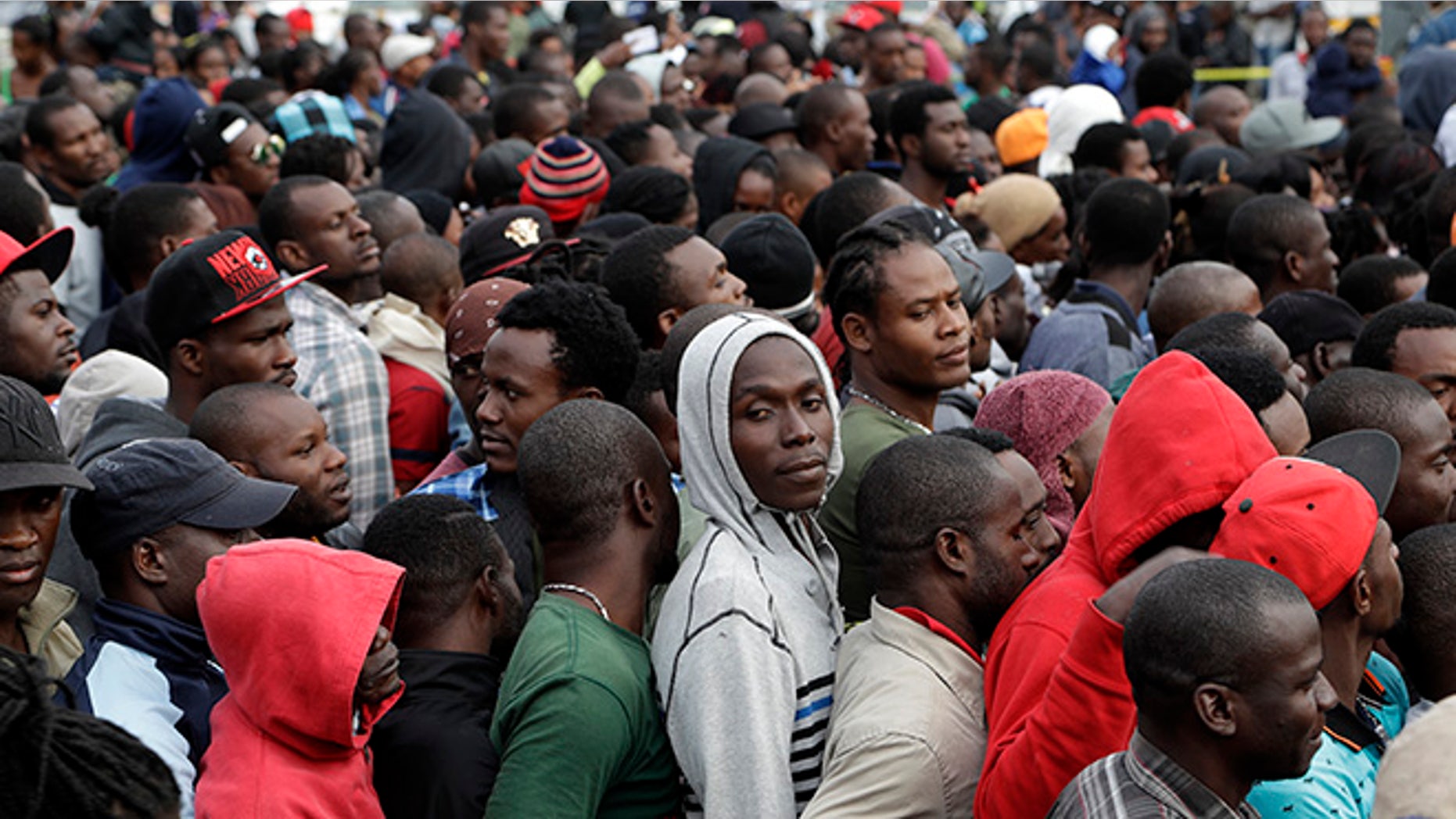 FILE - In this Oct. 3, 2016 file photo, Haitians line up at an immigration agency in Tijuana, Mexico, with the hope of gaining an appointment to cross to the U.S. side of the border. A surge in border crossings and a lack of immigration jail space have prompted the federal government to start releasing Haitian immigrants who have been entering the country in large numbers in recent months, backtracking on a pledge to jail the migrants. A U.S. government official said the decision to free Haitians arriving in Arizona and California is in response to a lack of jail space. Thousands of Haitians have arrived at the U.S. border with Mexico in recent months, many after traveling 7,000 miles by foot, taxi and bus. (AP Photo/Gregory Bull, File)