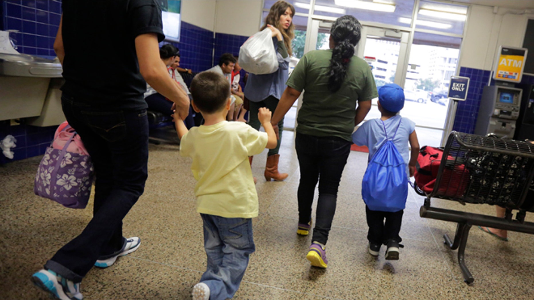 FILE - In this July 7, 2015, file photo, immigrants from El Salvador who entered the country illegally walk through a bus after they were released from a family detention center in San Antonio. With tens of thousands of Central American families arriving on the U.S.-Mexico border in the last two years, federal authorities have crafted a new plan to try to encourage more of them to show up for immigration court. Starting on Thursday, Jan. 21, 2016, as many as 800 families who pass an initial asylum screening can join the program in Los Angeles, New York, Washington, Chicago and Miami. Case workers will be assigned to help them with daily tasks such as finding transportation to immigration court and enrolling their children in school. (AP Photo/Eric Gay, File)