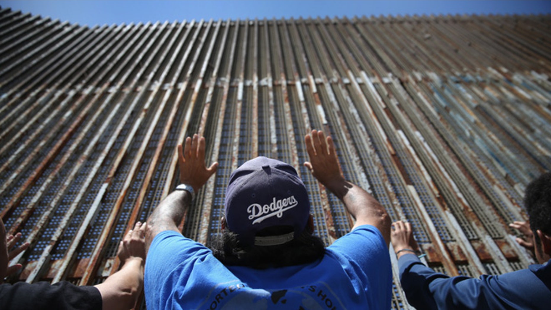 TIJUANA, MEXICO - MAY 01: Immigrant advocacy members pray at the U.S.-Mexico border fence on May 1, 2016 in Tijuana, Mexico. Mexicans on the Tijuana side can approach the border fence at any time. The U.S. Border Patrol, however, tightly controls the San Diego, CA side and allows visitors to speak to loved ones through the fence during specific weekend hours at "Friendship Park," which straddles the border. The park is the only place along the 1,954-mile border where such interactions are permitted by U.S. authorities. On only three occassions have U.S. officials allowed a gate to be opened at the park for pre-screened separated family members to embrace. (Photo by John Moore/Getty Images)
