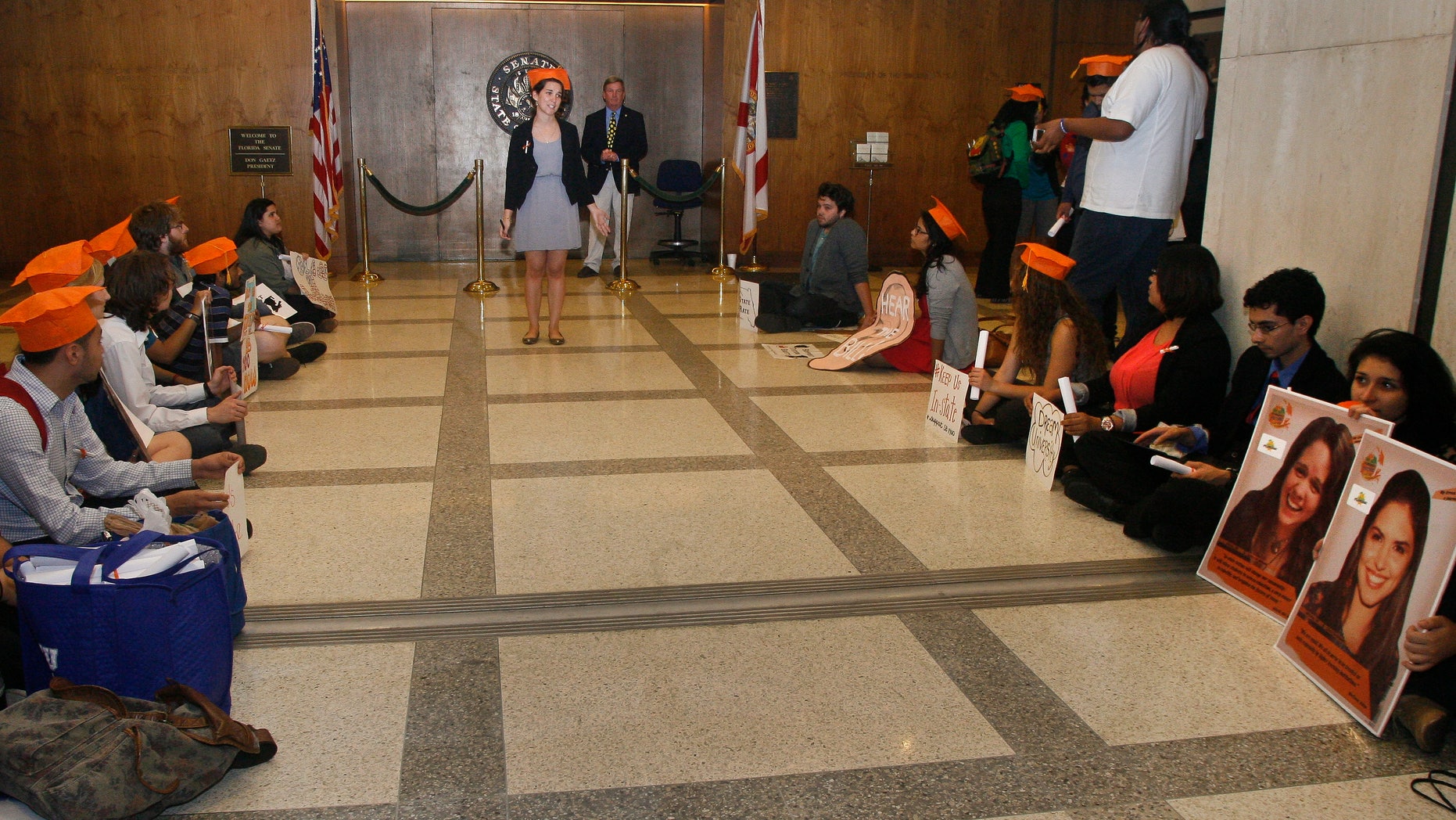 At center, Evelyn Rivera, a student at Valencia College in Orlando, Fla., speaks to students participating in a "Dream University" sit-in Thursday April 24, 2014, outside the Senate on the fourth floor of the Capitol in Tallahassee, Fla. The students are urging legislators to pass the in-state tuition bill, Senate Bill 1400 - Postsecondary Student Tuition. The bill is currently being held up in the Senate. (AP Photo/Phil Sears)