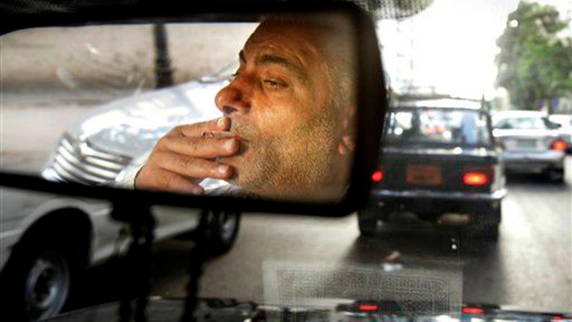 A man smokes in a car.