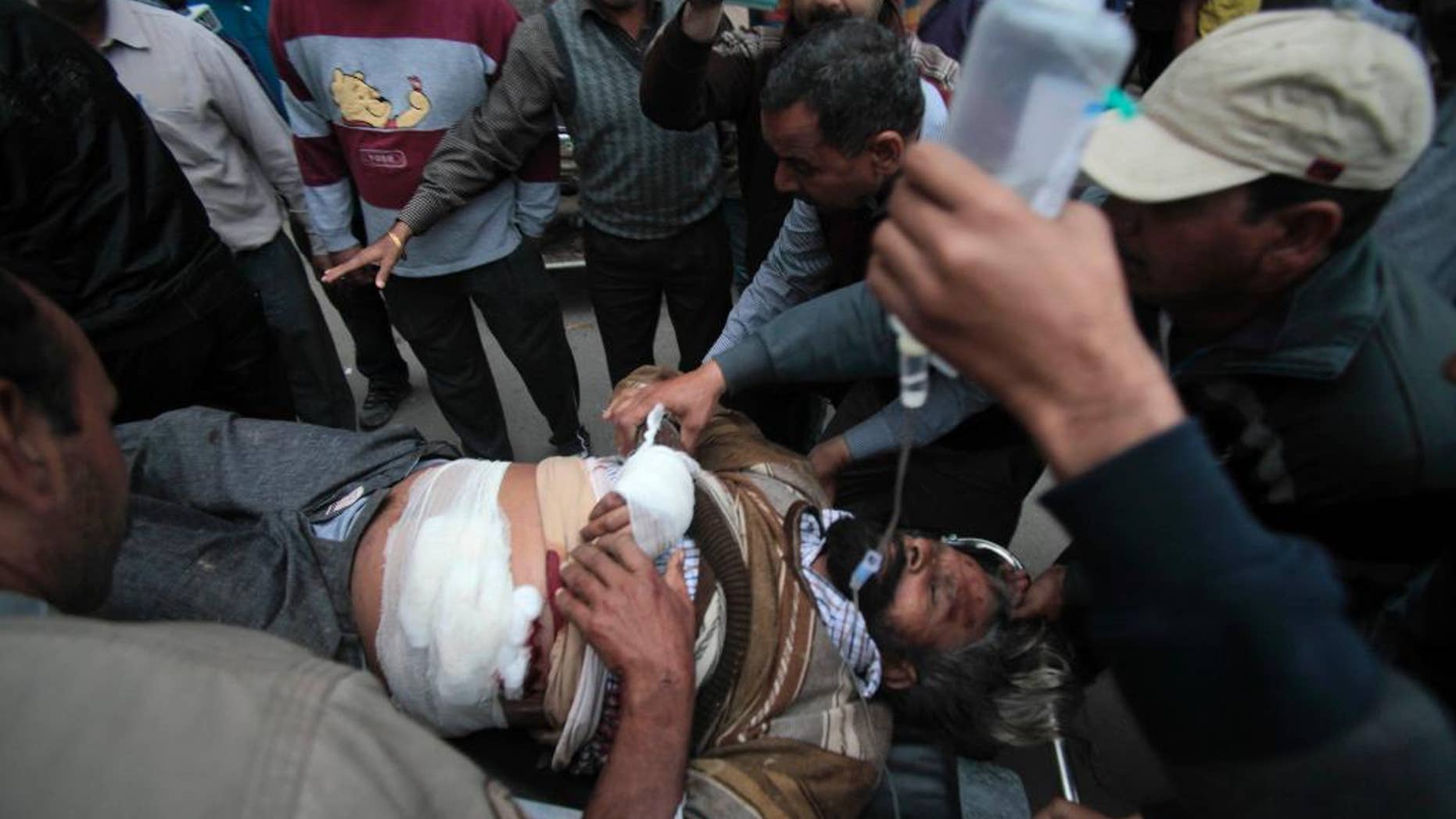 An injured man is carried on a stretcher for treatment to the Government Medical College after an attack in Jammu, India, Friday, March 28, 2014. One person was killed and three others injured Friday when unidentified gunmen wearing army uniform stopped a vehicle on the Jammu-Pathankot National Highway and shot its occupants, police said. The gunmen later escaped in the same vehicle. (AP Photo/Channi Anand)