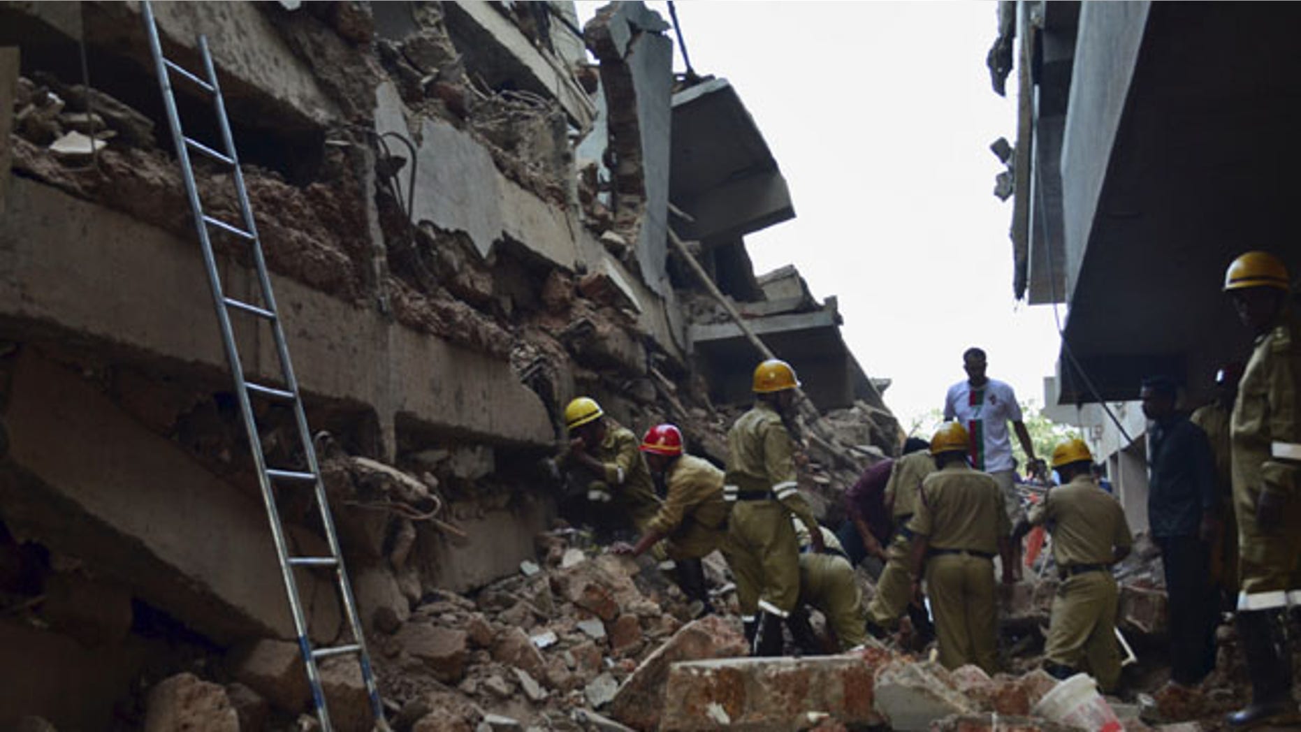January 4, 2014: Rescue workers stand amid the debris of a building that collapsed in Canacona, a city about 44 miles from the state capital of Panaji, India. (AP Photo)