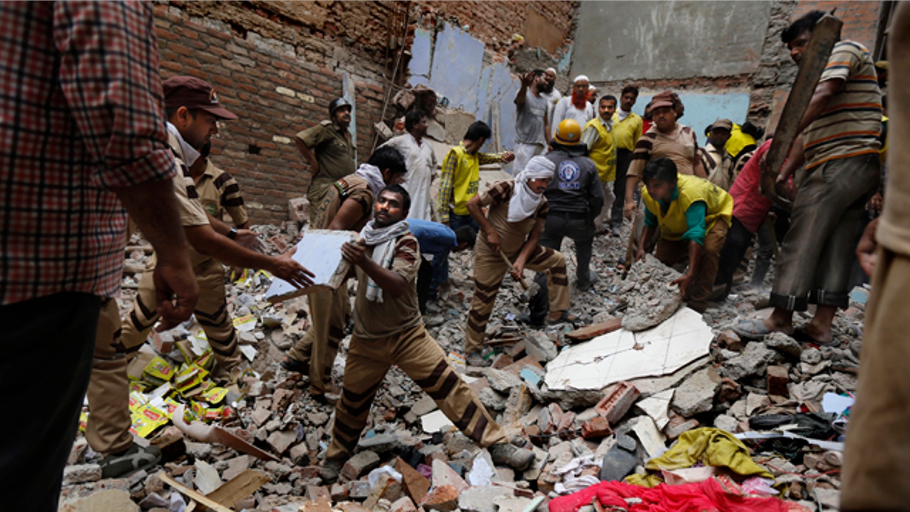June 28, 2014: Rescue workers clear debris at the site of a building collapse in New Delhi, India. (AP Photo/Altaf Qadri)