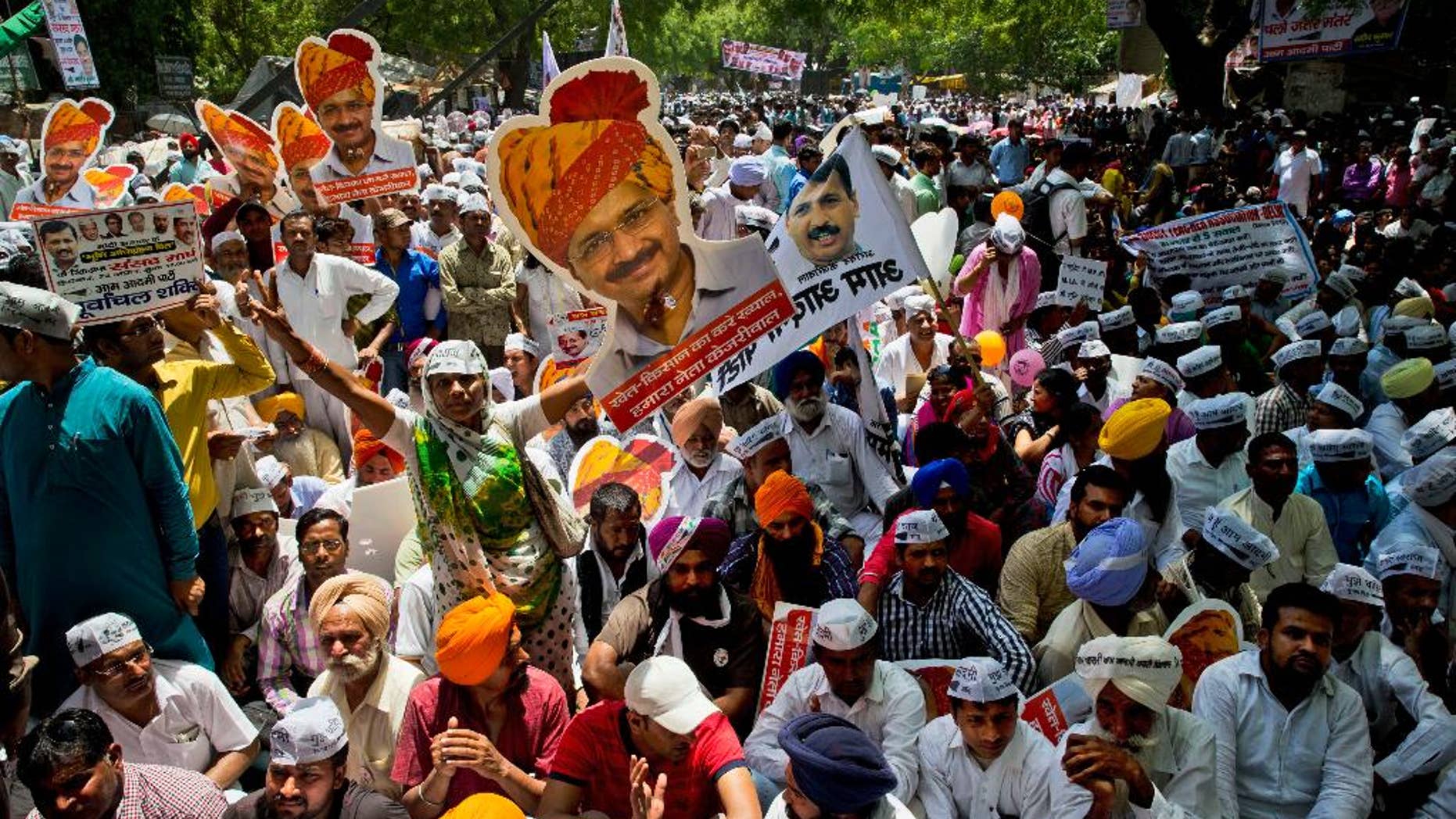 Indian farmers and Aam Aadmi Party or Common man’s party supporters display pictures of Delhi Chief Minister leader Arvind Kejriwal at a rally near the Indian parliament in New Delhi, India, Wednesday, April 22, 2015. Indian farmers and the opposition parties are protesting against a government plan to ease rules for obtaining land for industry and development projects. (AP Photo/Saurabh Das)